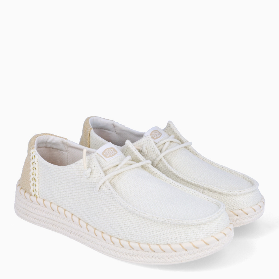 Náuticos transpirables de la marca Hey Dude, modelo WENDY. Exterior de los náuticos en textil color blanco. Interior en textil color blanco. Cierre de los náuticos Hey Dude con cordón elástico blanco. Naúticos con suela de goma con 3cm de cuña. Estos náuticos Hey Dude WENDY son el complemento clásico que necesitas esta temporada. No te puede faltar en tu armario.