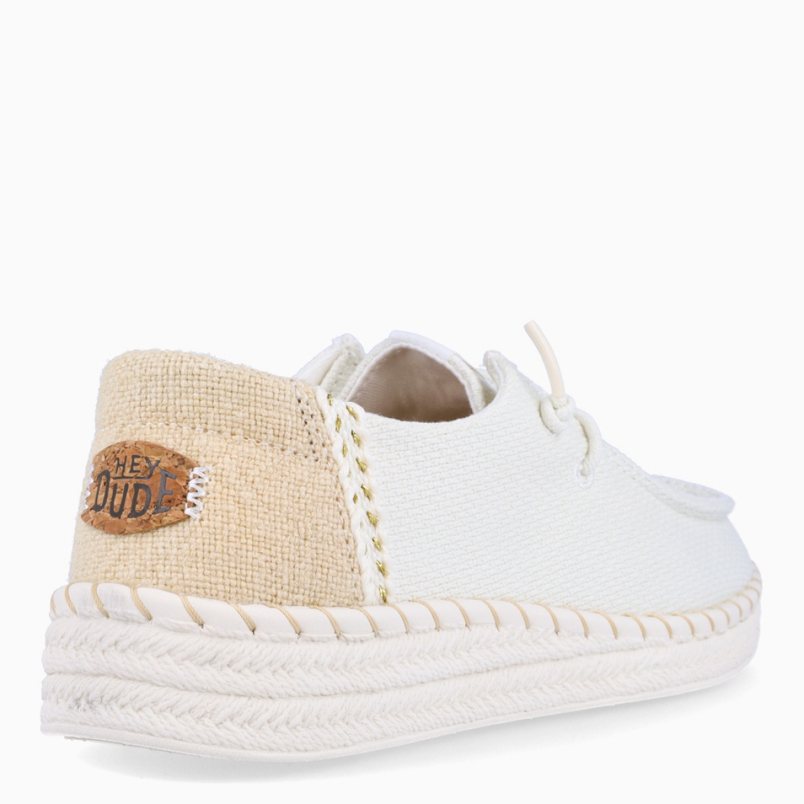 Náuticos transpirables de la marca Hey Dude, modelo WENDY. Exterior de los náuticos en textil color blanco. Interior en textil color blanco. Cierre de los náuticos Hey Dude con cordón elástico blanco. Naúticos con suela de goma con 3cm de cuña. Estos náuticos Hey Dude WENDY son el complemento clásico que necesitas esta temporada. No te puede faltar en tu armario.