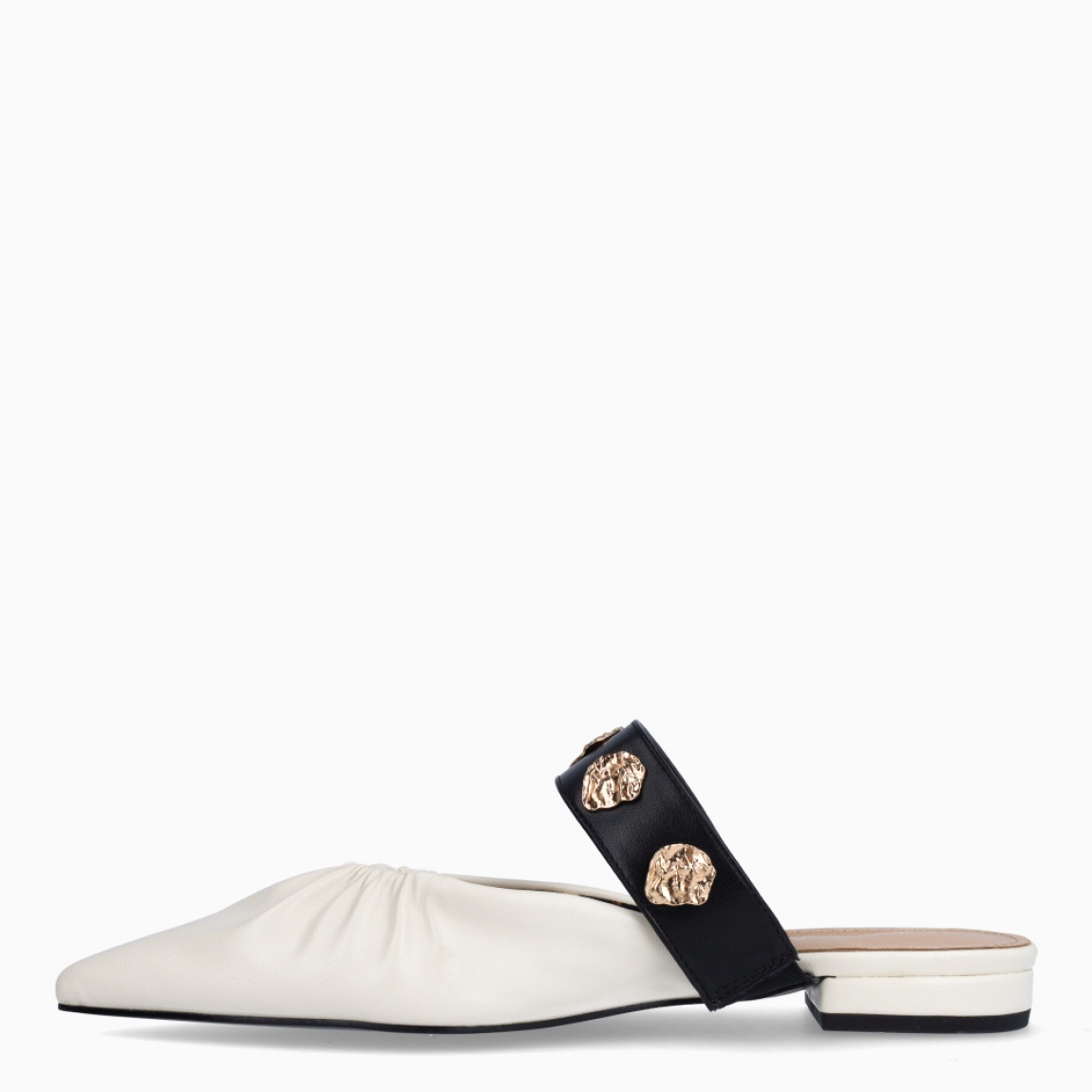 Salones destalonados de la marca Lola Casademunt, modelo ELOISE. Elaborado en piel color blanco con efecto corrugado, punta de lápiz y detalle de tira negra con adornos dorados en pala. Salones planos para máxima comodidad. Salones Lola Casademunt ELOISE, ideal para combinar con atuendos casuales o de oficina.