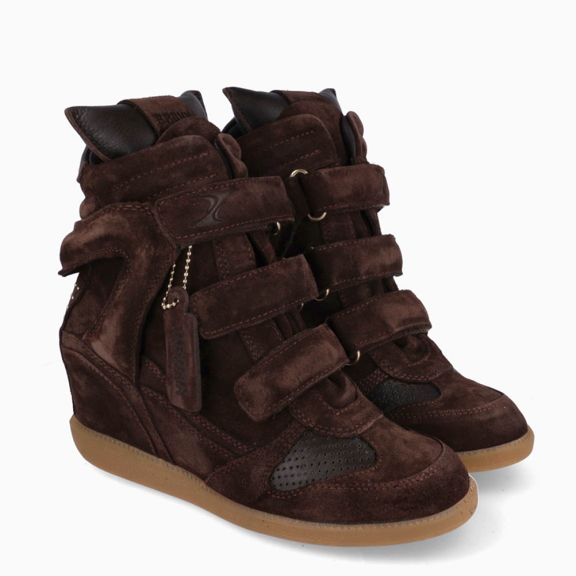 Botines de la marca Bronx, modelo JAE-YY. Elaborados en ante color marrón con detalle en rejillas y efecto acolchado. Cierre de los botines con tres velcros en toda la pala. Interior con plantilla acolchada extraíble para máxima comodidad. Suela con cuña interior de 5cm de altura. Estos botines Bronx JAE-YY son un complemento que combina comodidad deportivas con toque femenino. Ideal en ofrecer un look moderno y divertido, además de una comodidad inigualable!