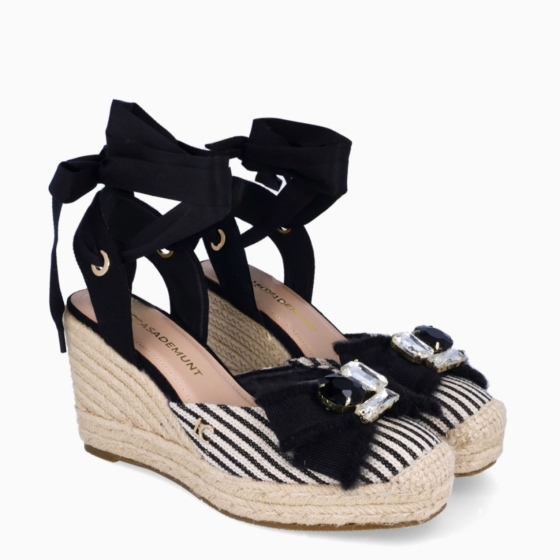 Alpargatas de la marca Lola Casademunt, modelo WENDY. Elaboradas en textil a rayas blanco y negro con adorno de piedrería en pala. Interior en piel color nude. Alpargatas Lola Casademunt con cierre en tirantes largos color negro. Suela con cuña alta de 9cm de altura. Estas alpargatas Lola Casdemunt WENDY son ideales para esta temporada!