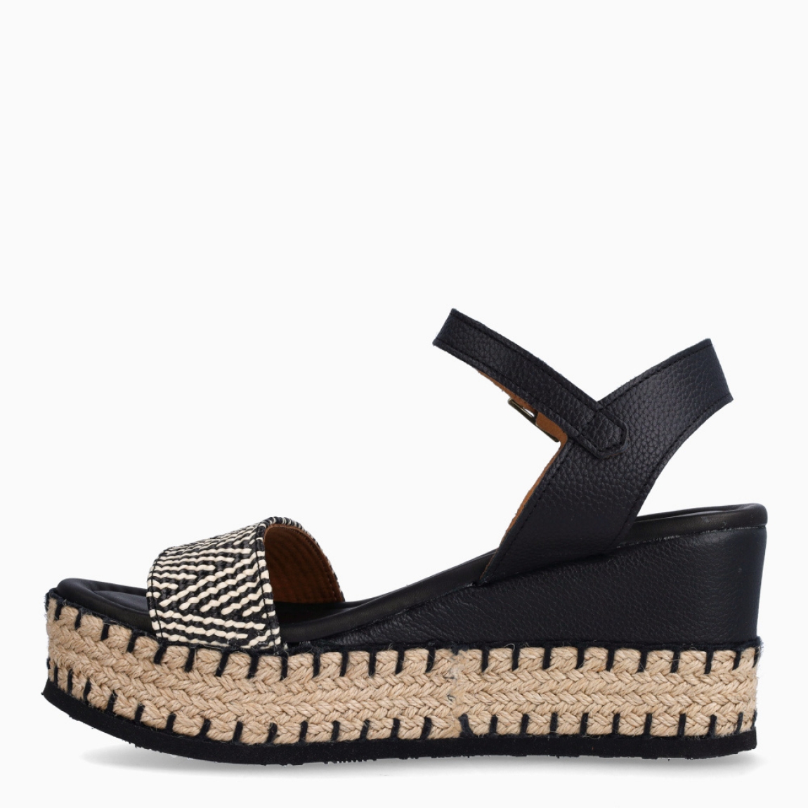 Sandalias de la marca Itse, modelo FLORA. Exterior de las sandalias en rafia color negro y blanco. Interior de las sandalias en piel color negro. Cierre de las sandalias Itse con hebilla en tobillo y cuña de 8cm de altura. Estas sandalias Itse FLORA son el complemento ideal para crear diferentes looks esta temporada, y sobre todo, gozar de una comodidad espectacular en tu día a día.