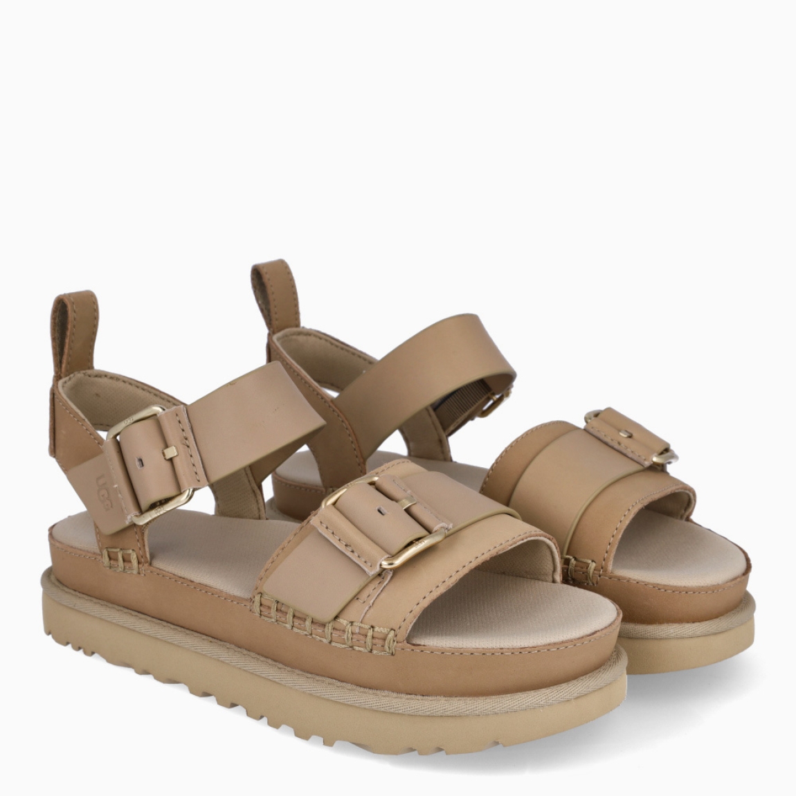 Sandalias de la marca UGG, modelo GOLDENSTAR VILLA. Elaboradas en piel color gris con tiras en la pala. Estas sandalias UGG son ligeras y muy cómodas gracias a la suela de EVA de caña de azúcar y la plantilla contorneada, que las hacen ideales para explorar la ciudad o cualquier otro destino. Las tiras están hechas de una combinación de nobuk suave y piel auténtica y cuentan con una hebilla ajustable en el tobillo para que las adaptes como quieras. Con plataforma de 4cm de altura. Estas UGG GOLDENSTAR VILLA, que cuentan con elementos emblemáticos como los ribetes con costuras y detalles de pespunte cuadrado, te permiten disfrutar de la increíble sensación UGG® también durante los meses más cálidos.