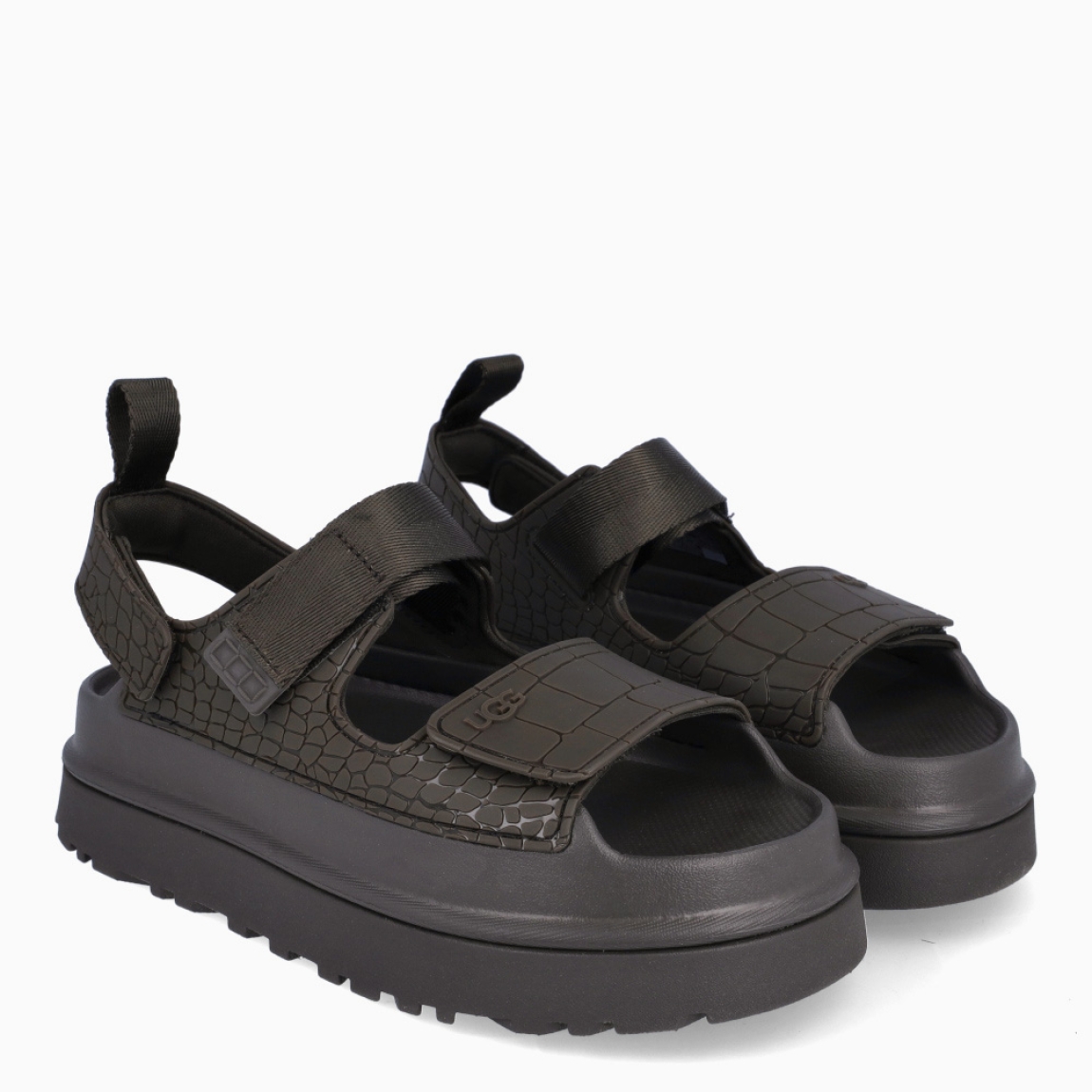 Sandalias de la marca UGG, modelo GOLDENGLOW. Sandalias con forro del empeine fabricado con fibras de poliéster 100 % reciclado color verde con estampado de cocodrilo. Empeine de TPU grabado. Cierre de las UGG con velcro en pala y tobillo, las tiras están fabricadas con fibras de poliéster 100 % reciclado. Entresuela de EVA de caña de azucar. Suela de goma con plataforma. Estas sandalias UGG GOLDENGLOW son un complemento que te brindará una comodidad única!