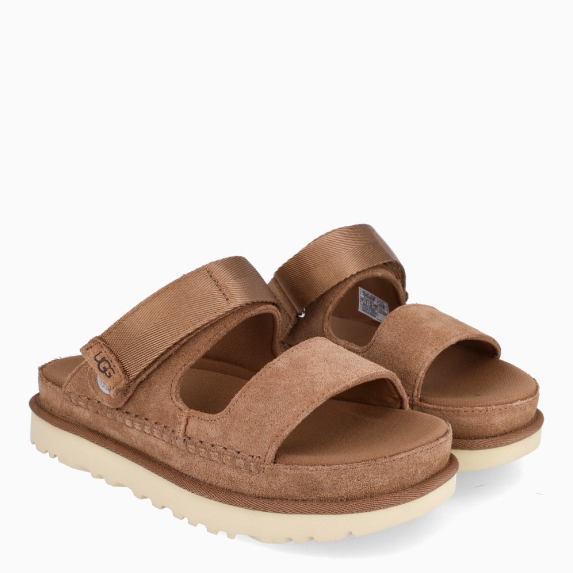 Sandalias de la marca UGG, modelo GOLDEN. Elaboradas en ante color cuero con tiras en la pala, y cierre con velcro. Estas sandalias UGG son ligeras y muy cómodas gracias a la suela de EVA de caña de azúcar y la plantilla contorneada, que las hacen ideales para explorar la ciudad o cualquier otro destino. Las tiras están hechas de una combinación de nobuk suave y piel auténtica. Estas UGG GOLDEN, que cuentan con elementos emblemáticos como los ribetes con costuras te permiten disfrutar de la increíble sensación UGG también durante los meses más cálidos.