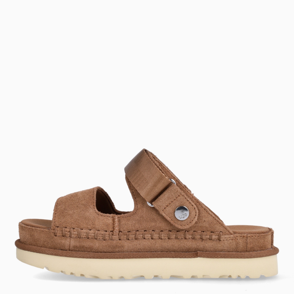 Sandalias de la marca UGG, modelo GOLDEN. Elaboradas en ante color cuero con tiras en la pala, y cierre con velcro. Estas sandalias UGG son ligeras y muy cómodas gracias a la suela de EVA de caña de azúcar y la plantilla contorneada, que las hacen ideales para explorar la ciudad o cualquier otro destino. Las tiras están hechas de una combinación de nobuk suave y piel auténtica. Estas UGG GOLDEN, que cuentan con elementos emblemáticos como los ribetes con costuras te permiten disfrutar de la increíble sensación UGG también durante los meses más cálidos.