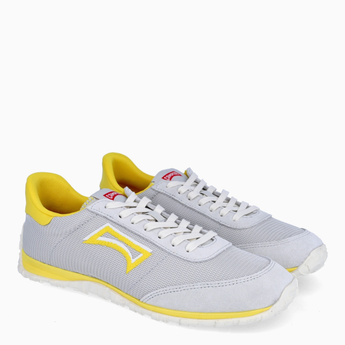 Deportivas de la marca Camper, modelo K866. Exterior en naylon color gris efecto rejilla con detalle en amarillo en logo y talón. Deportivas clásicas con cierre de cordones en pala color blanco. Suela de goma dentada. Estas deportivas Camper K866 son unas clásicas, ideales para tu día a día!