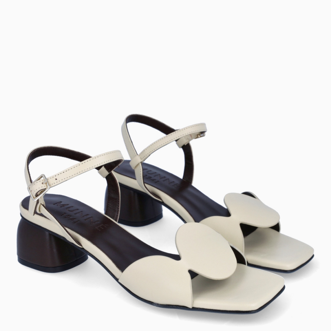 Sandalias de la marca Munné, modelo SIRA. Elaboradas en piel color beig con detalle de círculos en la pala. Interior en color marrón. Cierre de sandalias Munné con hebilla en tobillo. Suela con tacón de 3cm de altura. Estas sandalias Munné SIRA son un complemento clásico, ideal en comodidad y estilo!