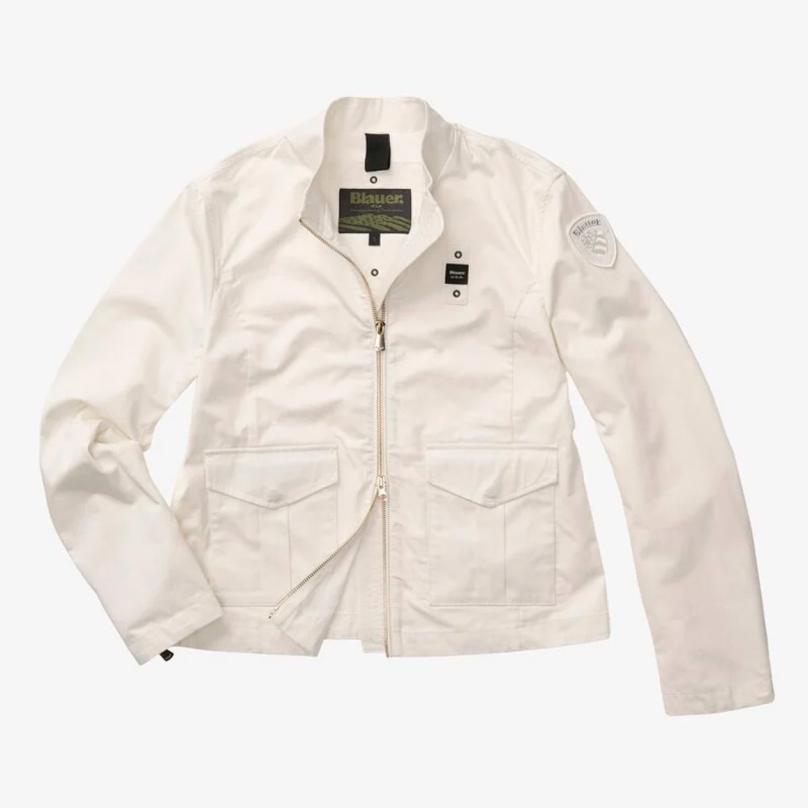 Chaqueta de la marca Blauer, modelo BLAKE. Chaqueta elaborada en algodón con cuello coreano color blanco. Las líneas son fluidas y esenciales con detalles modernos y refinados para un estilo casual pero elegante. Cierre de chaqueta Blauer con cremallera. Bolsillos dobles abiertos y con automático. Puño cerrado con cremallera profunda. Bolsillo interno con Velcro. Parche y presilla con logo. Chaqueta Blauer BLAKE ideal para ti!