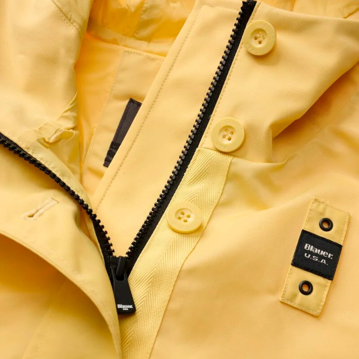 Chaqueta corta de la marca Blauer, modelo MARCELLA. Chaqueta de moda en nylon brillante color amarillo en el delantero y neopreno en tonalidad en la capucha, en el trasero y en la solapa con cremallera interna. Prenda ligeramente más larga en la espalda para dar un estilo único y característico ideal para las estaciones intermedias. Chaqueta Blauer con capucha fija, cierre con cremallera y botones, bolsillos con botón, bolsillos internos con velcro y parche y presilla con logo. Chaqueta Blauer MARCELLA, complemento ideal para esta temporada!
