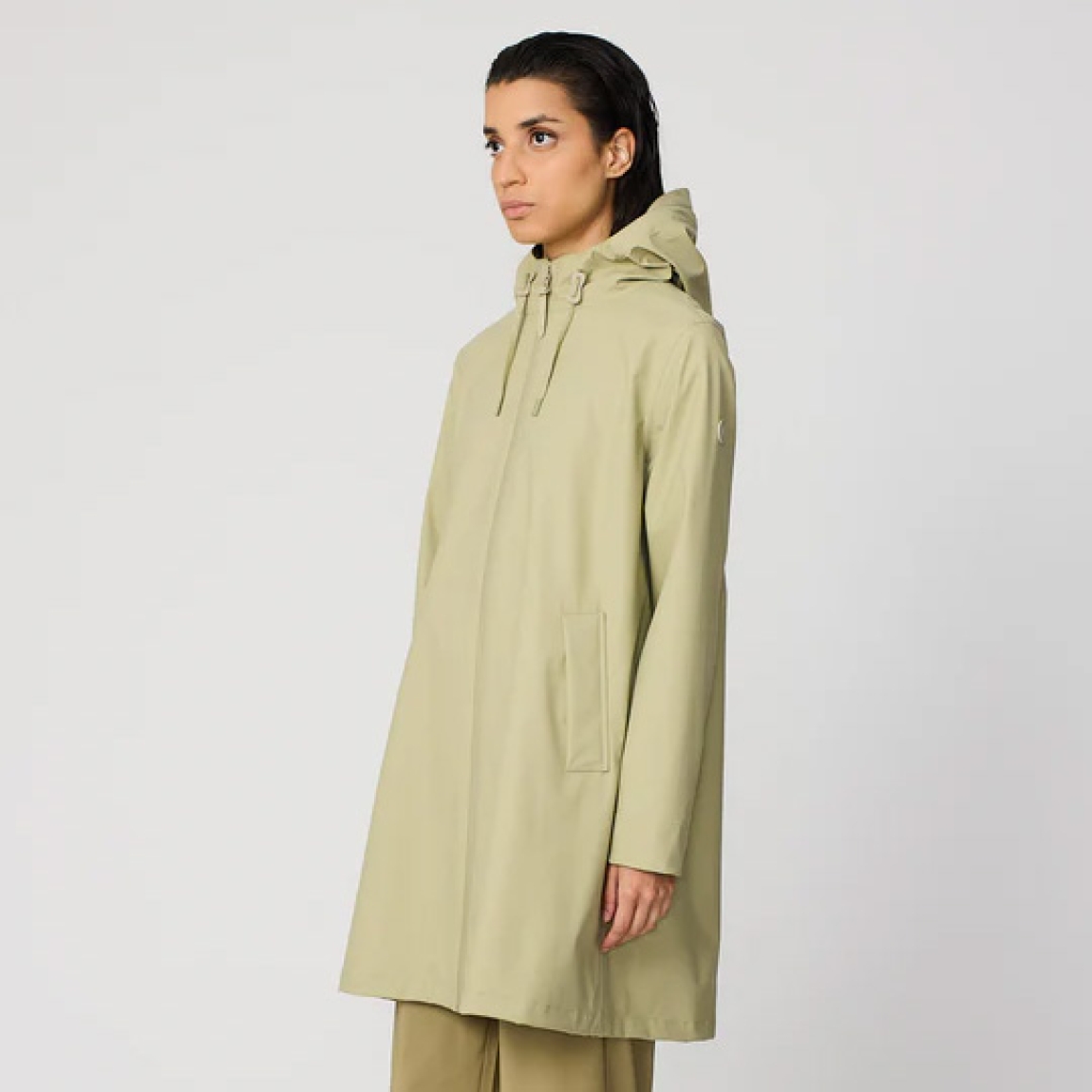 Chubasquero impermeable de mujer de la marca Tanta, modelo NUOVOLA. El impermeable Nuovola está confeccionado con nuestro icónico tejido de poliuretano color verde y cuenta con un pliegue en la espalda que aporta un volumen único en forma de A. Diseñado para el uso diario en temporadas de transición, El largo a mitad del muslo se complementa con una cremallera sellada en la parte delantera y con puños corta vientos en el interior de la manga para una protección adicional contra el clima más impredecible. Se ajusta a la talla real. Chaqueta larga lisa Tanta NUOVOLA ideal ara esta temporada!