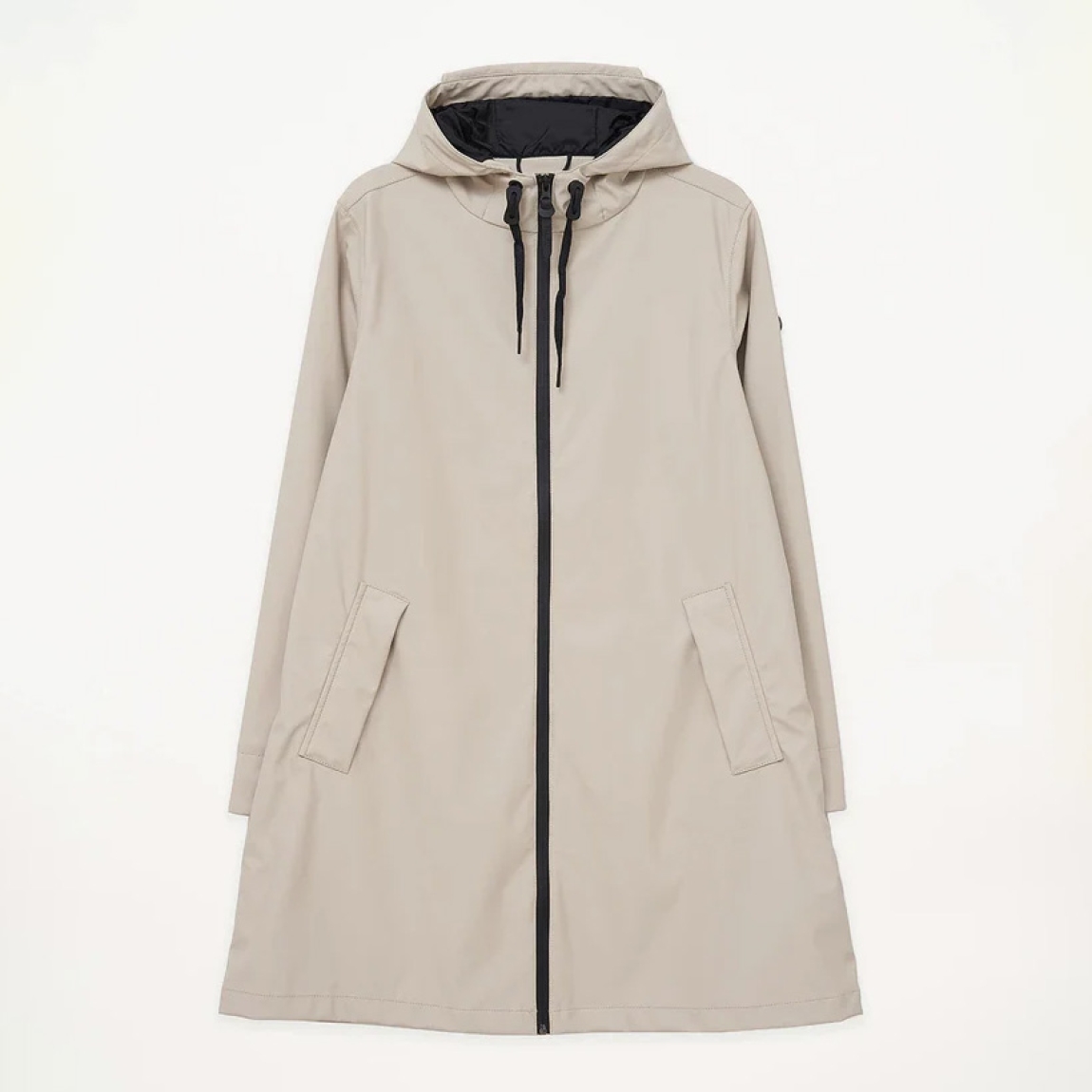 Chubasquero impermeable de mujer de la marca Tanta, modelo NUOVOLA. El impermeable Nuovola está confeccionado con nuestro icónico tejido de poliuretano color beige y cuenta con un pliegue en la espalda que aporta un volumen único en forma de A. Diseñado para el uso diario en temporadas de transición, El largo a mitad del muslo se complementa con una cremallera sellada en la parte delantera y con puños corta vientos en el interior de la manga para una protección adicional contra el clima más impredecible. Se ajusta a la talla real. Chaqueta larga lisa Tanta NUOVOLA ideal ara esta temporada!