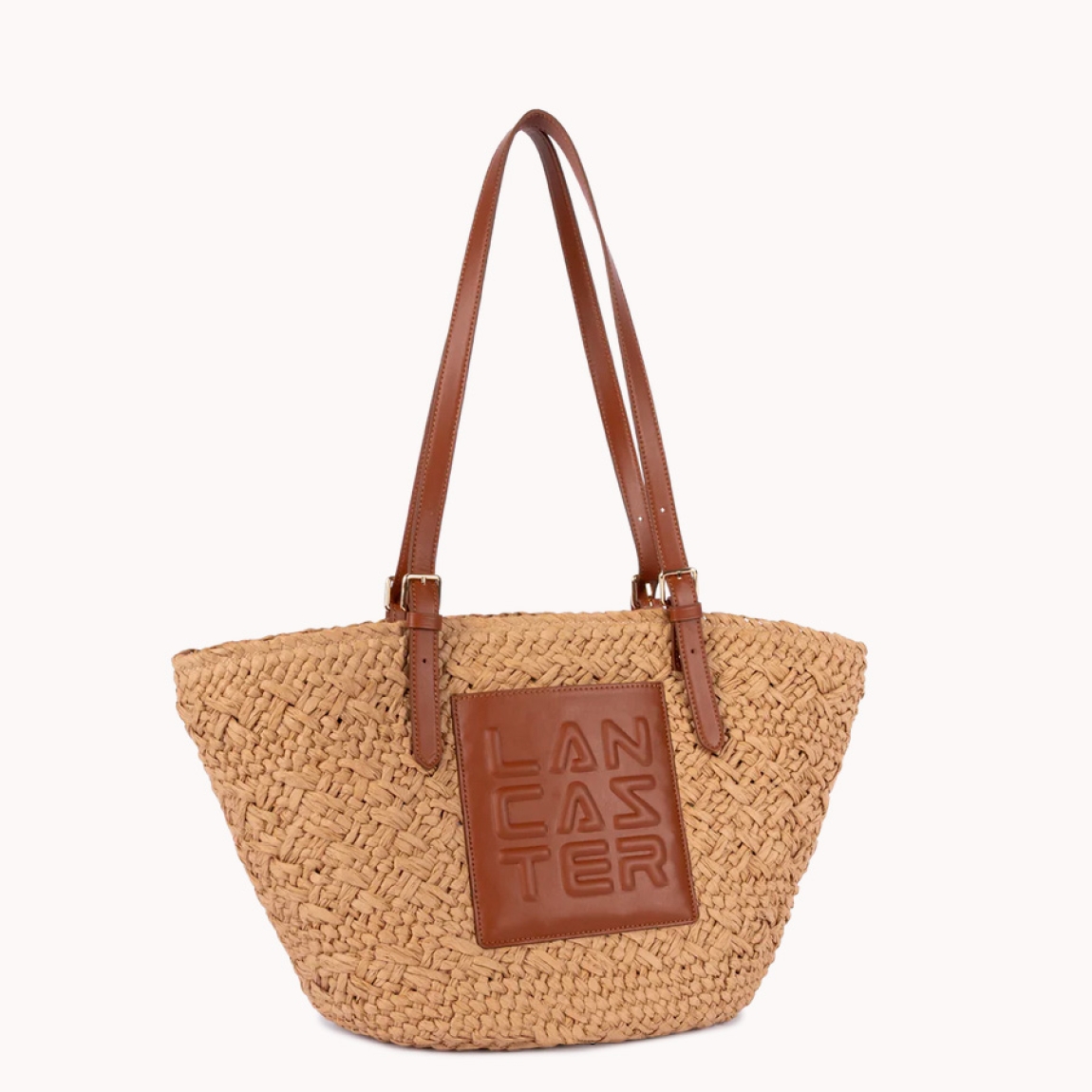 Bolso de la marca Lancaster, modelo ÉPAULEE. Este bolso bandolera está confeccionado en mimbre con guarnición de cuero de vachette color marrón. Su cierre del bolso Lancaste es con cremallera, la cual garantiza el almacenamiento de sus efectos personales, además de un sencillo bolsillo frontal, un sencillo bolsillo interior y un sencillo bolsillo interior doble. Diseñado para una cartera, con un estilo natural y practicidad para el día a día. Medidas: alto 26cm y ancho 45cm.