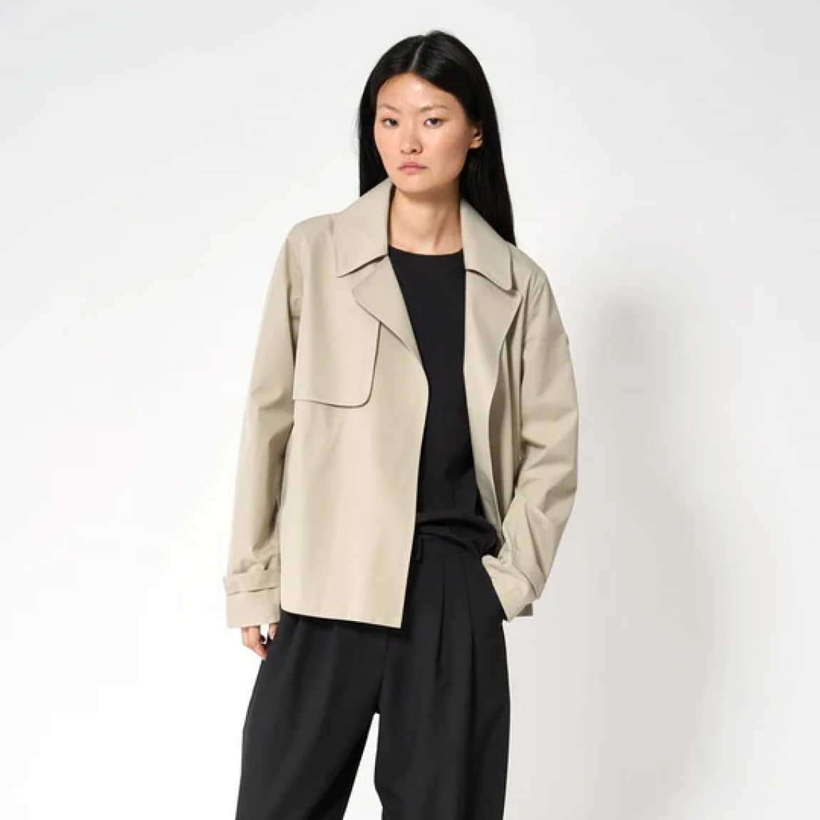 Chaqueta corta impermeable de la marca Tanta, modelo NIWL. Chaqueta sin costuras Niwl está confeccionado en tejido de sarga de poliéster color beig. Es 100% impermeable y cuenta con todas las costuras selladas para una protección superior. Los detalles de la prenda incluyen un canesú en la espalda y otro en el lado derecho de la parte delantera, botones a presión ocultos y una capucha desmontable con cordón ajustable. Diseñado con un corte impecable, esta chaqueta Tanta, modelo Niwl combina elegancia con una alta funcionalidad.