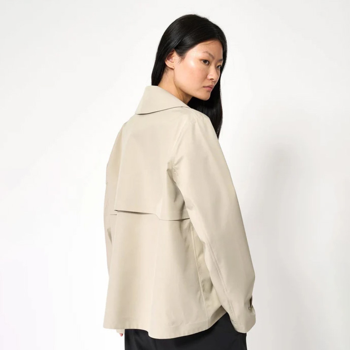 Chaqueta corta impermeable de la marca Tanta, modelo NIWL. Chaqueta sin costuras Niwl está confeccionado en tejido de sarga de poliéster color beig. Es 100% impermeable y cuenta con todas las costuras selladas para una protección superior. Los detalles de la prenda incluyen un canesú en la espalda y otro en el lado derecho de la parte delantera, botones a presión ocultos y una capucha desmontable con cordón ajustable. Diseñado con un corte impecable, esta chaqueta Tanta, modelo Niwl combina elegancia con una alta funcionalidad.