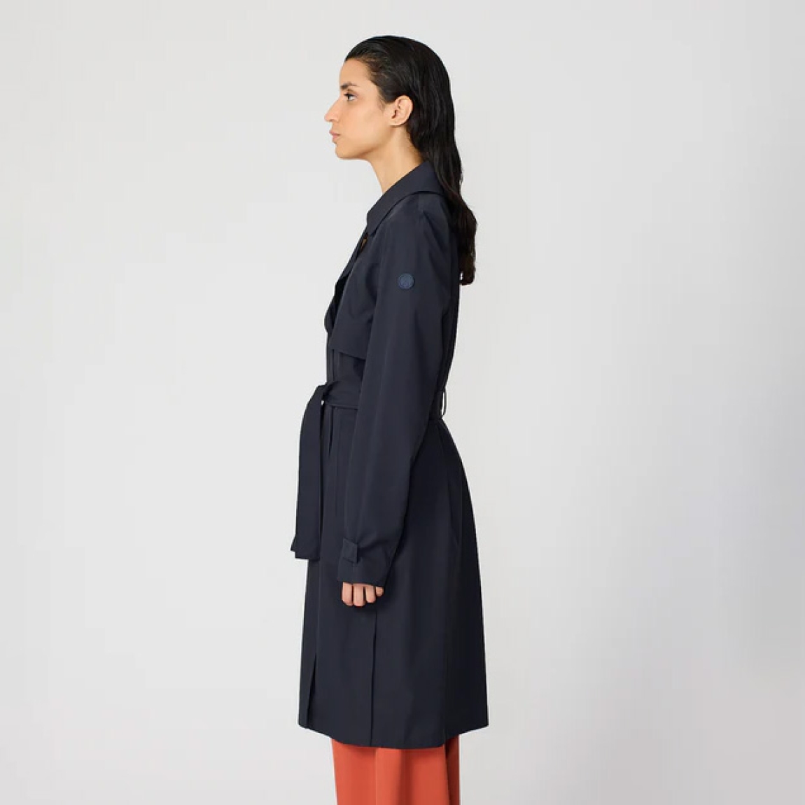 Chaqueta lisa larga de la marca Tanta, modelo TAGE. Chaqueta o gabarina impermeable sin costuras Tage está confeccionado en tejido de sarga de poliéster color azul marino. Es 100% impermeable y cuenta con todas las costuras selladas para una protección superior. Los detalles de la prenda incluyen dos canesús en la parte delantera y uno en la parte trasera, botones a presión ocultos, una cintura ajustable con cinturón y una capucha desmontable con cordón ajustable. Chaqueta Tanta dieñada con un corte impecable, el modelo Tage de Tanta combina elegancia con una alta funcionalidad.