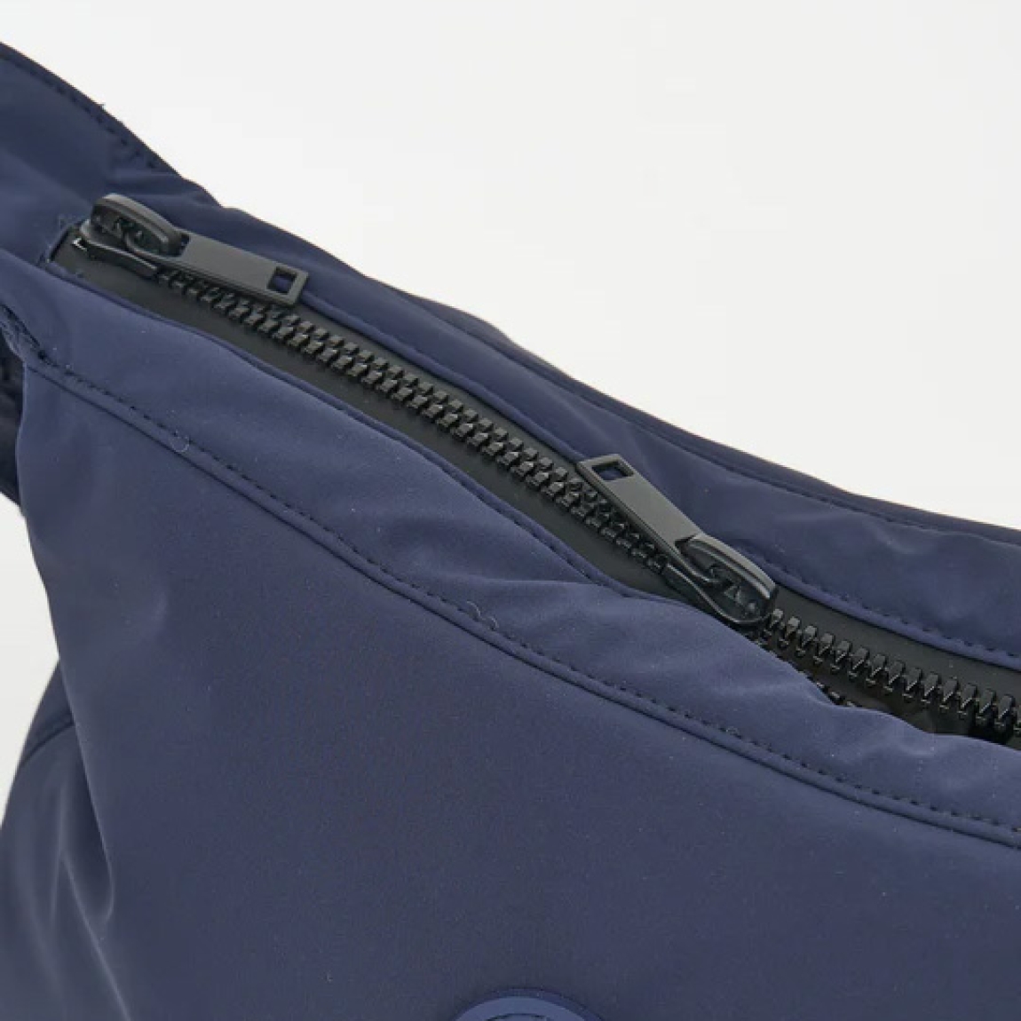 Bolso de la marca Tanta, modelo KUHIRÓ. Este bolso Tanta Kuhiró es un bolso de tamaño medio fabricado en Softshell ligero color azul marino con un acabado repelente al agua duradero. Los detalles del bolso Tanta incluyen un diseño curvado, una correa ajustable y un compartimento principal con una gruesa cremallera. Este modelo Kuhiró de Tanta, es un bolso versátil que puede llevarse al hombro o cruzado. Medidas: alto 22cm y ancho 32cm.