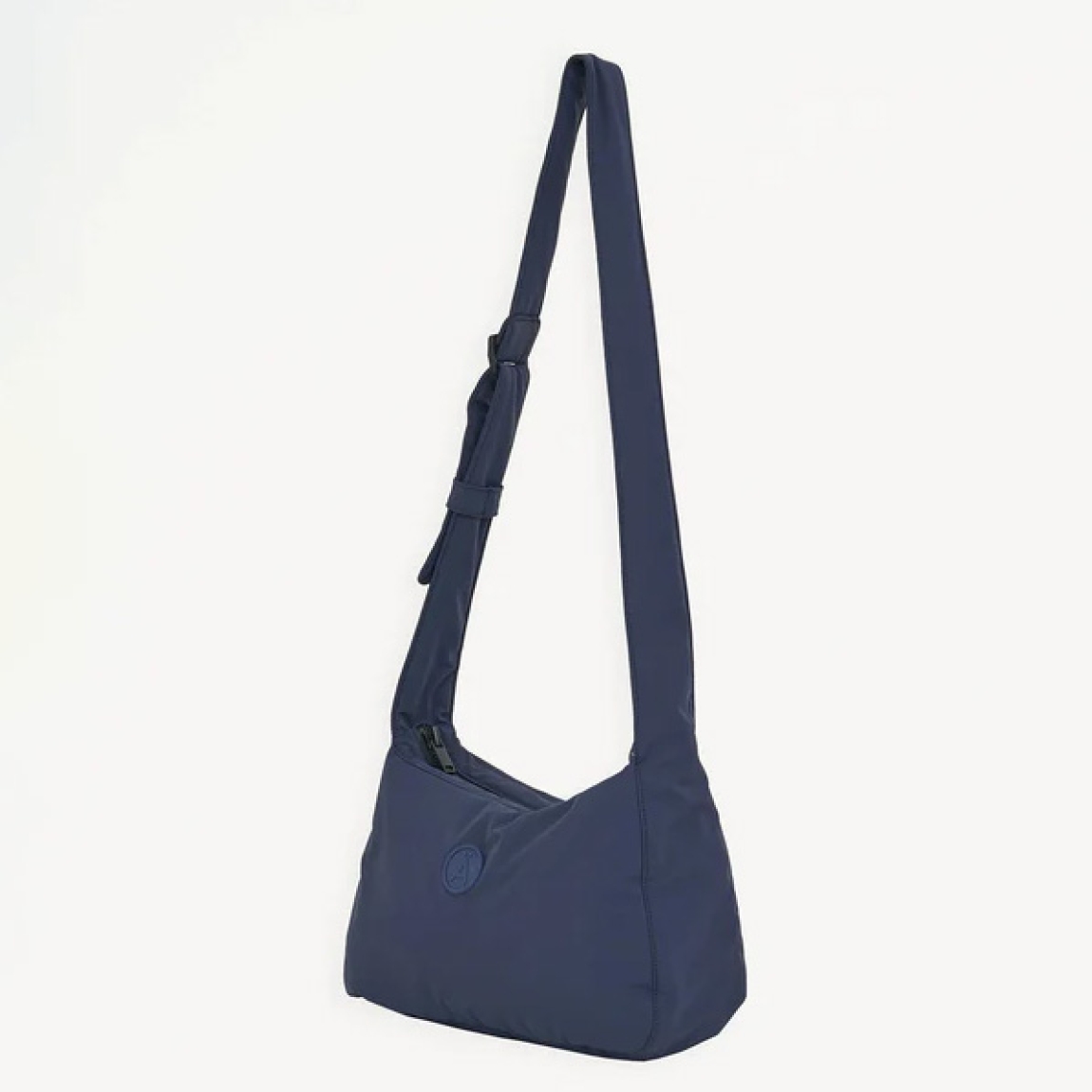 Bolso de la marca Tanta, modelo KUHIRÓ. Este bolso Tanta Kuhiró es un bolso de tamaño medio fabricado en Softshell ligero color azul marino con un acabado repelente al agua duradero. Los detalles del bolso Tanta incluyen un diseño curvado, una correa ajustable y un compartimento principal con una gruesa cremallera. Este modelo Kuhiró de Tanta, es un bolso versátil que puede llevarse al hombro o cruzado. Medidas: alto 22cm y ancho 32cm.