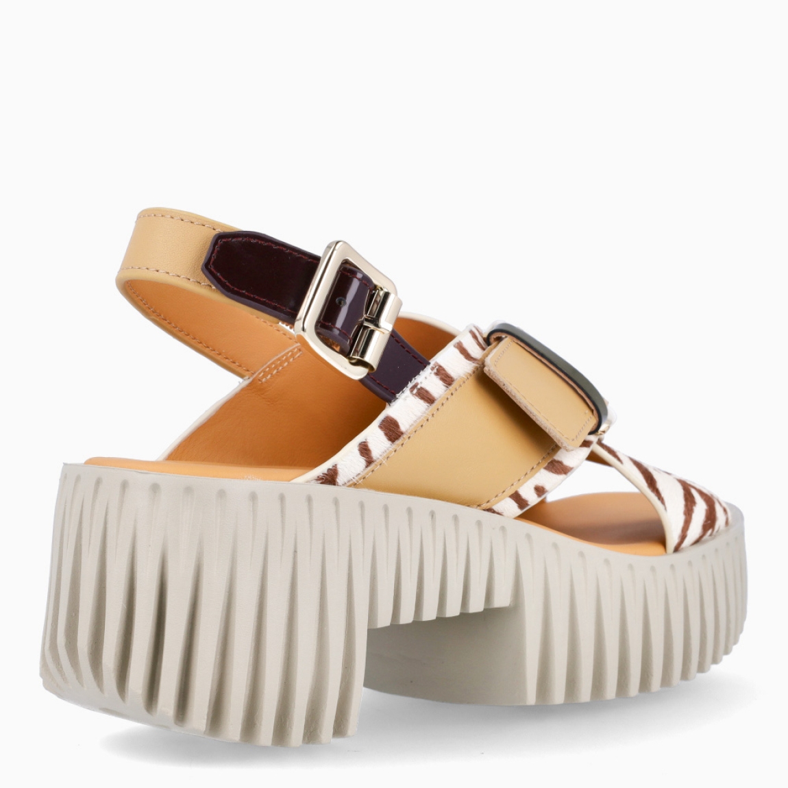 Sandalias de la marca 4CCCCEES, modelo PLIA JUNO. Sandalias elaboradas en piel con estampado animal print de cebra y beige. Con una silueta discreta y detalles divertidos, la sandalia JUNO de tiras anchas cruzadas es ideal para ocasiones formales o informales. Los vibrantes toques de color y las llamativas hebillas metálicas dan vida al diseño, demostrando una vez más la capacidad de la marca para combinar comodidad y estilo a la perfección. Modelo PLIA JUNO con cierre en hebilla, en pala y talón para mayor ajuste. Plataforma con suela dentada simulando bloques tallados con tacón de 6cm de altura. Este modelo 4CCCCEES PLIA JUNO, es una reinterpretación vanguardista de los tradicionales zuecos con una interpretación exquisita y moderna de una silueta clásica.