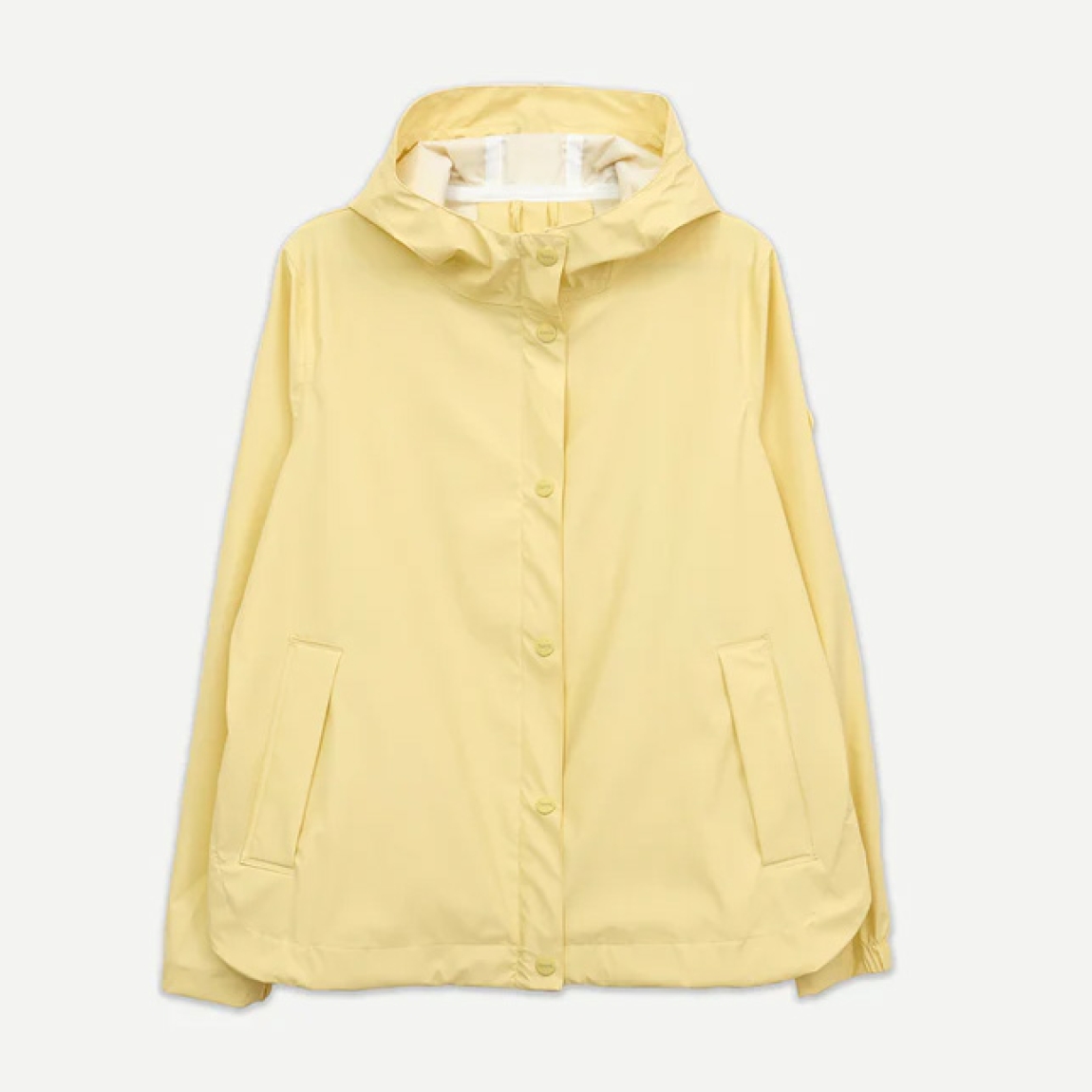 Chaqueta lisa de la marca Tanta, modelo NIMBUSELLE. Chaqueta impermeable ligera y moderna confeccionado en poliuretano fino color amarillo. Una versión más liviana de nuestro material icónico, ideal para los días cálidos y húmedos de primavera y verano. 100 % waterproof, con todas las costuras selladas, presenta una silueta joven y un bajo redondeado, ideal para el uso diario en días de lluvia y temperaturas suaves. Chaqueta Tanta NIMBUSELLE ideal para esta temporada!