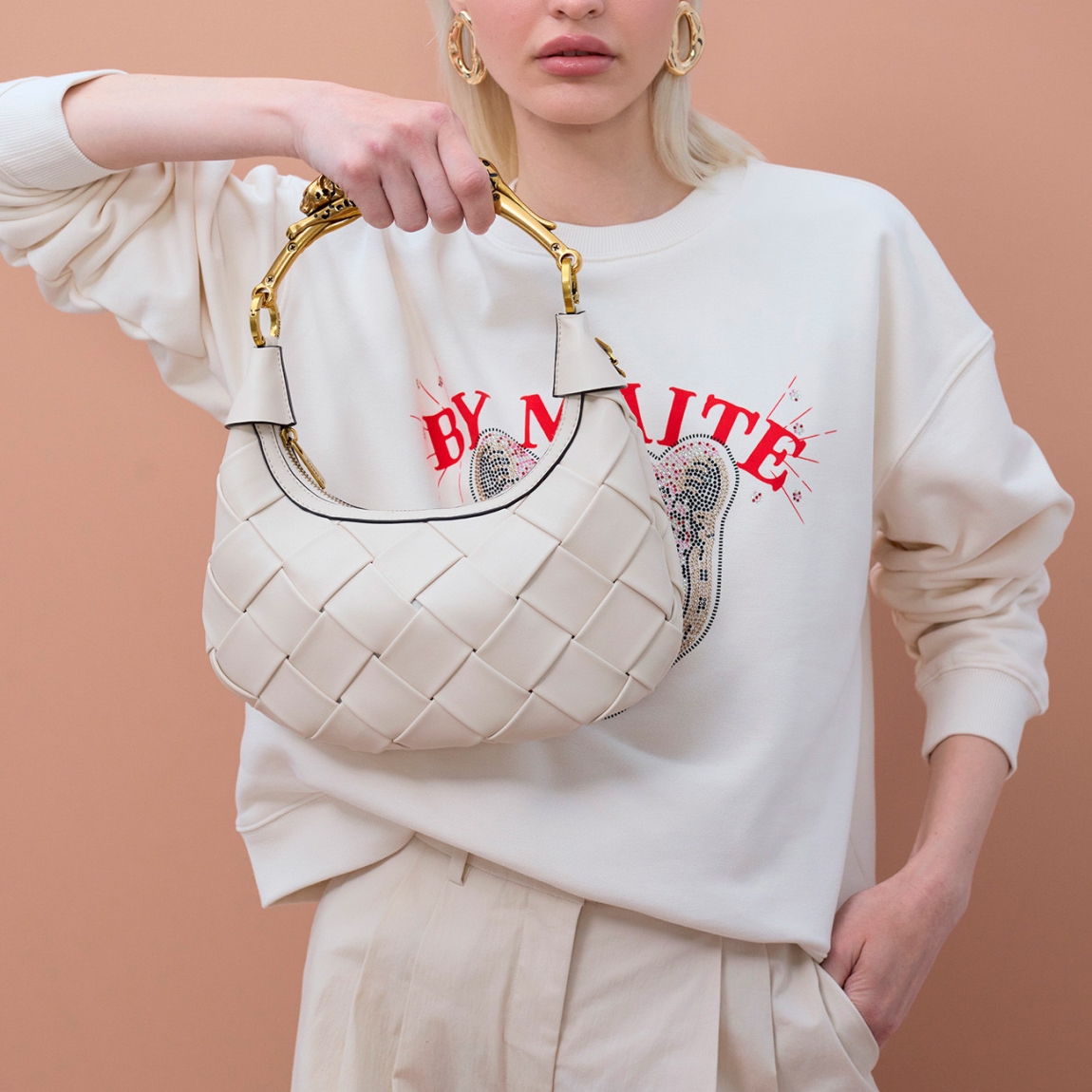 Bolso de la marca Lola Casademunt, modelo SIENA. Elaborado en piel con efecto trenzado color hielo en forma de media luna. Bolso con cierre en cremallera y logo metálico decorativo.. Asa de metal en forma de leopardo dorado, ideal para un look sofisticado. Bolso Lola Casademunt SIENA, complemento ideal para ti!ALTO 15cm ANCHO 28cm PROFUNDIDAD 6cm