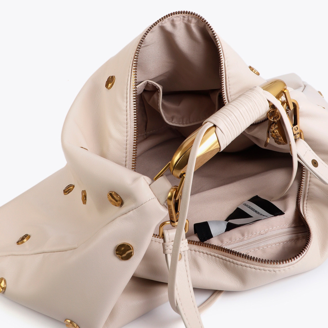 Bolso hobo de la marca Lola Casademunt, modelo GLENDA. Bolso en color crema con tachas doradas y textura suave. Incluye un asa ajustable y detalles metálicos exclusivos. Cierre superior de cremallera y un interior espacioso con compartimentos para una organización óptima. Bolso Lola Casademunt ideal para llevarla en tu día a día!ALTO 30cm ANCHO 48cm PROFUNDIDAD 3cm
