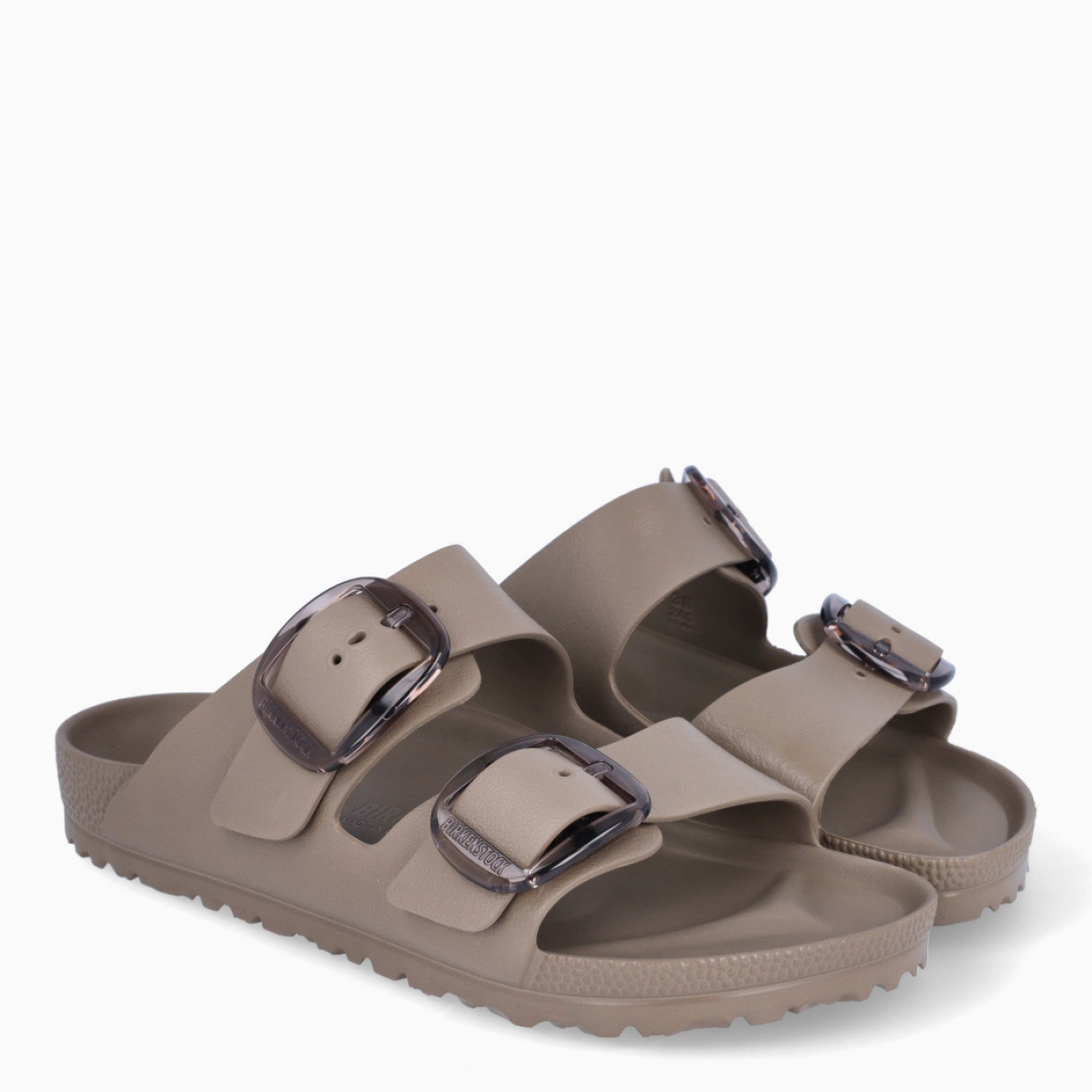 Sandalias de la marca Birkenstock, modelo ARIZONA EVA. Sandalias elaboradas en neopreno de alta calidad color taupe. Cierre de las sandalias con doble hebilla, en el empeine y la pala. Sandalias con suela plana y de goma. Estas sandalias Birkenstock ARIZONA EVA son un complemento clásico para esta temporada, podrás combinarlo con diferentes outifts y disfrutar de una comodidad máxima. No te puede faltar en el armario.