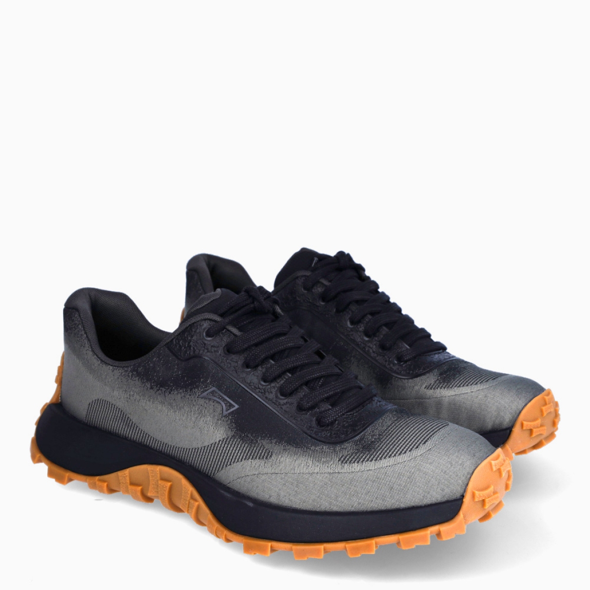 Deportivas de la marca Camper, modelo K101. Exterior en naylon color gris y detalle en negro degradado. Cierre con cordones negros. Suela de goma dentada camel. Estas deportivas Camper K101 son un complemento ideal para disfrutar de la comodidad al caminar.