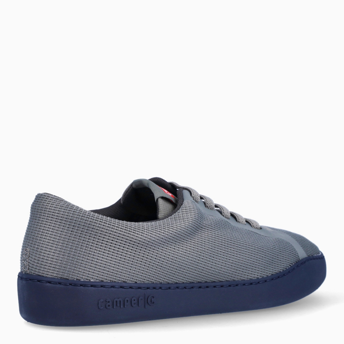 Deportivas de la marca Camper, modelo K82. Exterior en textil color gris con efecto rejilla y detalle del logo. Deportivas clásicas con cierre de cordones en pala color gris. Suela de goma plana. Estas deportivas Camper K82 son unas clásicas, ideales para tu día a día!