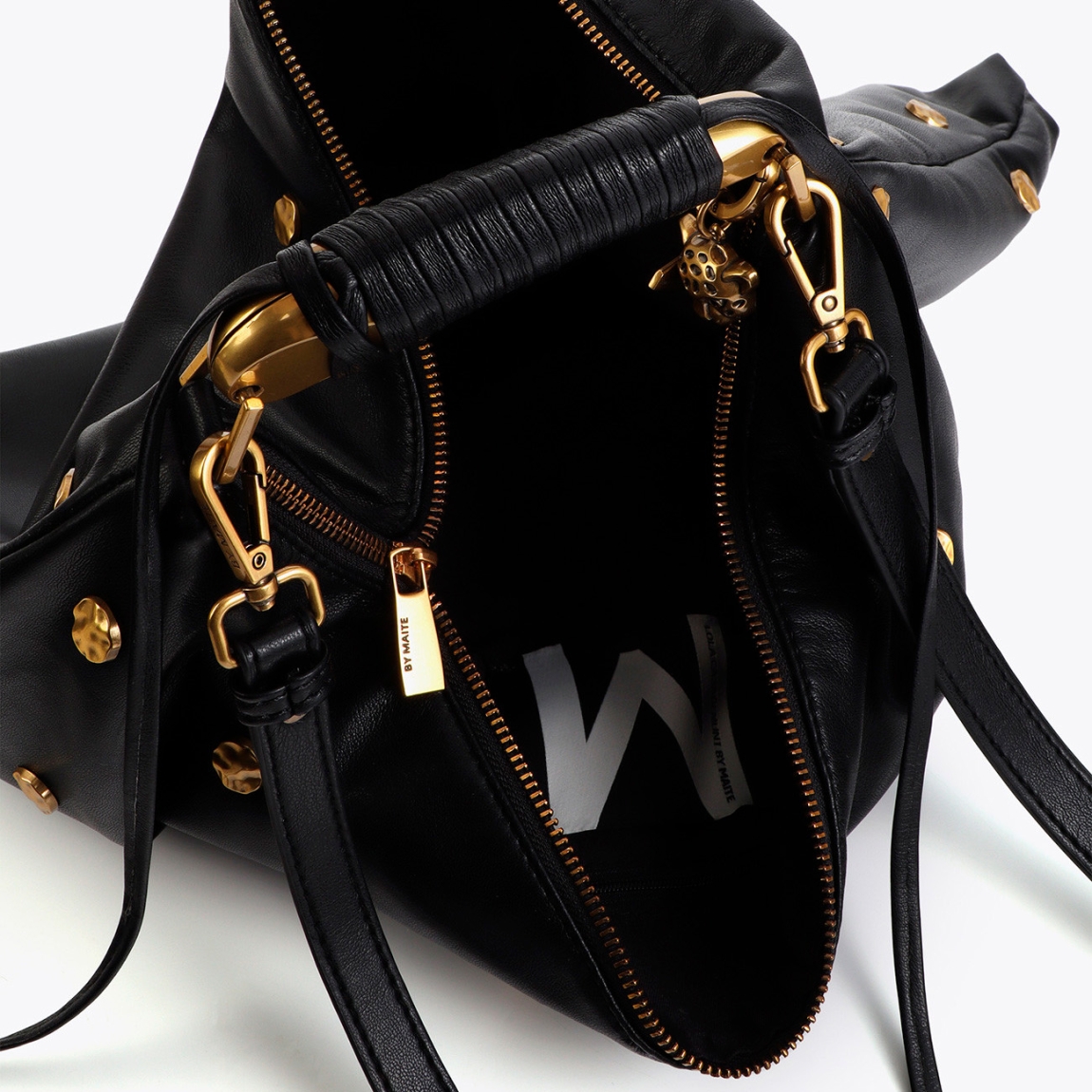 Elegante bolso bandolera de la marca Lola Casademunt, modelo LORENA_G. Elaborado en polipiel color negro con textura y decorado con tachas doradas. Asa ajustable y cierre magnético para mayor seguridad. Bolsillo interno para organización y detalle de charm metálico en el lateral. Bolso Lola Casademunt LORENA_G ideal para llevarlo a todos lados y marcar estilo!ALTO 27cm ANCHO 40cm