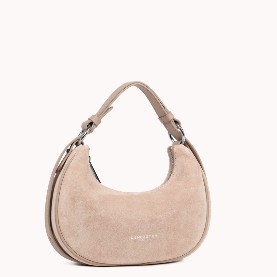 Este pequeño bolso bandolera de la marca Lancaster, modelo Suède está confeccionado en cuero de vaca con efecto ante de color beig. Incluye un bolsillo interior simple, un bolsillo interior con cremallera y un bolsillo trasero exterior con cremallera. Se puede llevar al hombro o cruzado. Bolso con logotipo en parte frontal. Bolso Lancaster Suède se ha convertido en un complemento ideal para llevar a todos lados, su forma en media luna le da un estilo único!