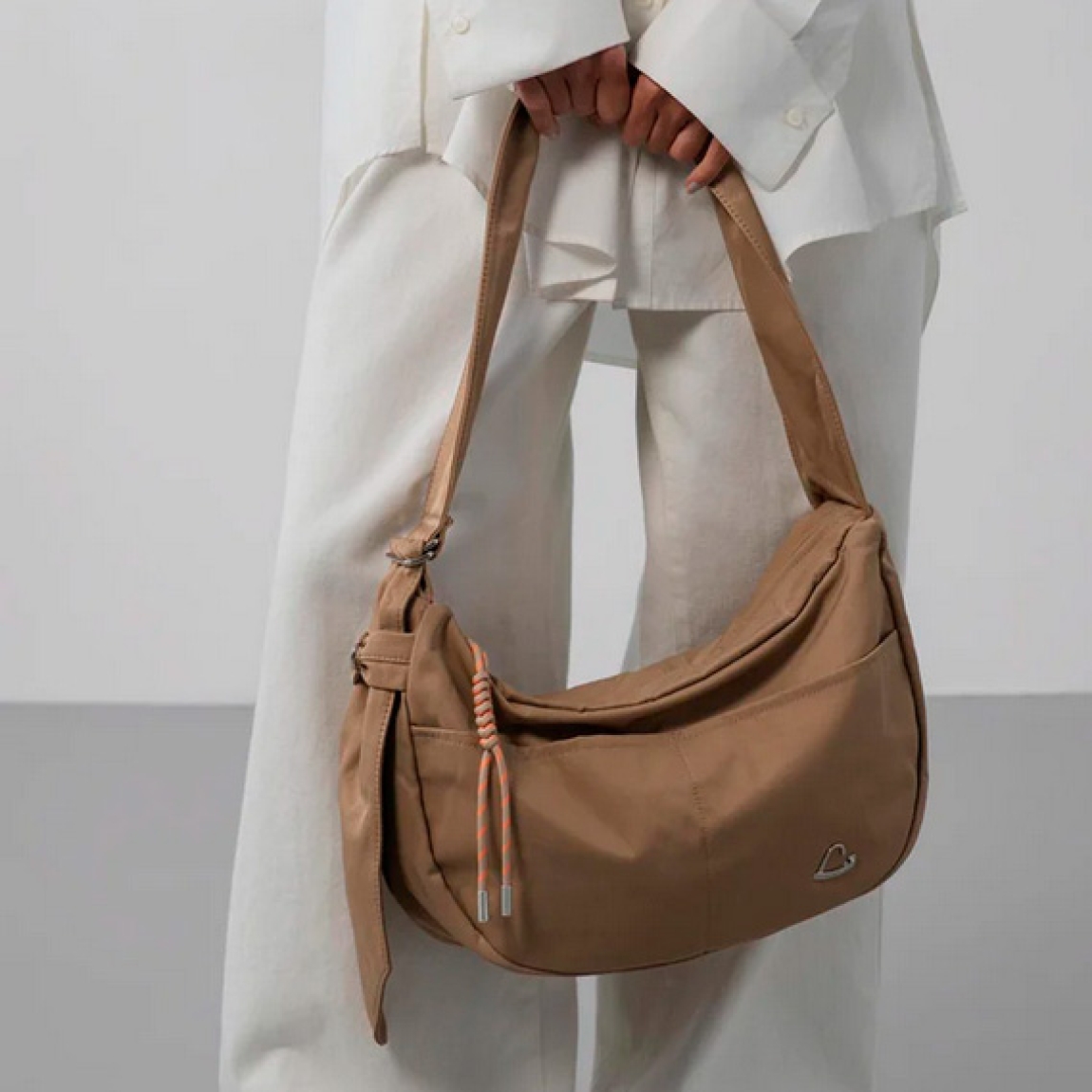 Este gran bolso de la marca Lancaster, modelo BASIC LOVE, está confeccionado en nylon/poliamida de color camel. Cuenta con un bolsillo exterior trasero con cremallera, dos bolsillos frontales simples, un bolsillo interior simple y un doble bolsillo interior simple. Se lleva cruzado o al hombro. Bolso Lancaster BASIC LOVE, complemento ideal para llevar a todos lados! Medidas: altura 25cm y ancho 40cm.