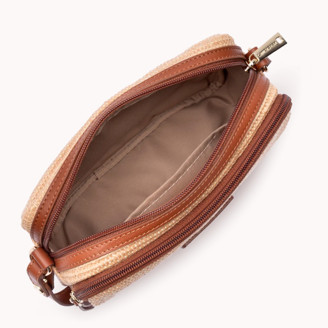 Bolso bandolera de la marca Lancaster, modelo Mini Osier. Este bolso está confeccionado en polipropileno con detalles de piel de vacuno color marrón. Cuenta con un bolsillo frontal con cremallera, un bolsillo interior con cremallera y un bolsillo interior simple. Se lleva al hombro o cruzado. Bolso Lancaster Mini Osier ideal para llevarlo en tu día a día esta temporada. Medidas: alto 15cm y ancho 22cm.