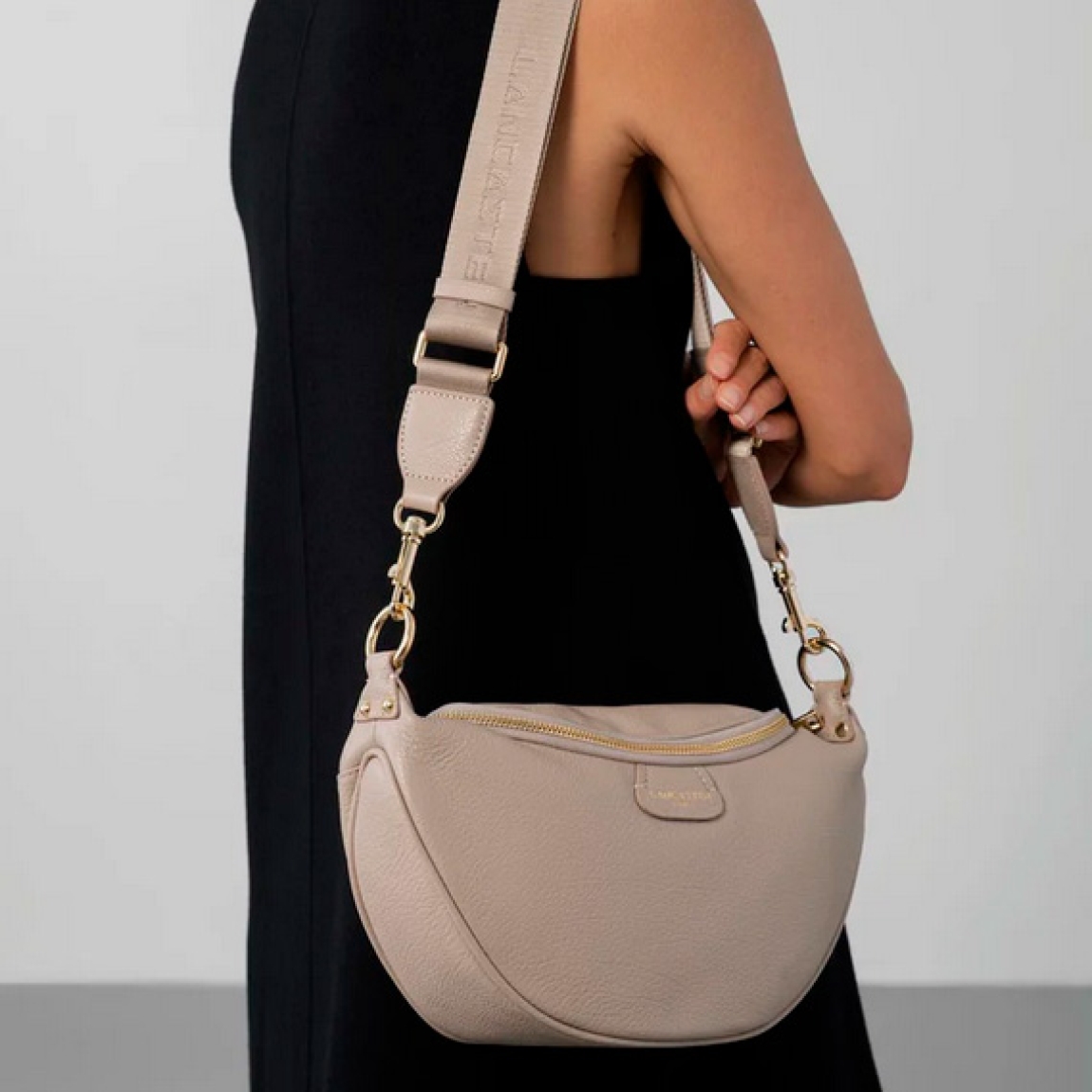 Bolso riñonera de la marca Lancaster, modelo DUNE. Esta riñonera está confeccionada en ecopiel de vacuno granulada color beig. Tiene un gran bolsillo principal y un bolsillo exterior con cremallera. Puede llevarse en la cintura o ladeada. Bolso ideal para llevar a todos lados en tu día a día. Medidas: alto 18cm y ancho 30cm.