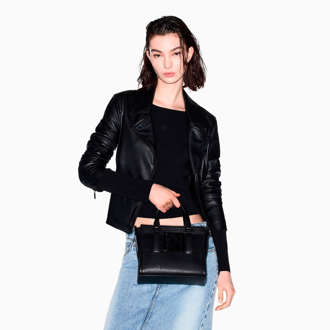 Bolso de la marca Armani Exchange, modelo URSULA. Bolso con diseño minimalista elaborado en piel con efecto troquelado color negro, y detalle de logotipo en parte frontal. Cierre con cremallera. Bolso perfecto para completar looks urbanos y sofisticados. La textura técnica del tejido le aporta un toque moderno y resistente, mientras que su gran capacidad lo hace ideal para afrontar el día con estilo y practicidad. Bolso Armani Exchange con amplio compartimento principal. Se puede llevar al hombro o en la mano. Bolso Amani Exchange URSULA, es un accesorio imprescindible para quienes aprecian la sencillez refinada. Medidas: alto 20cm y ancho 24cm.