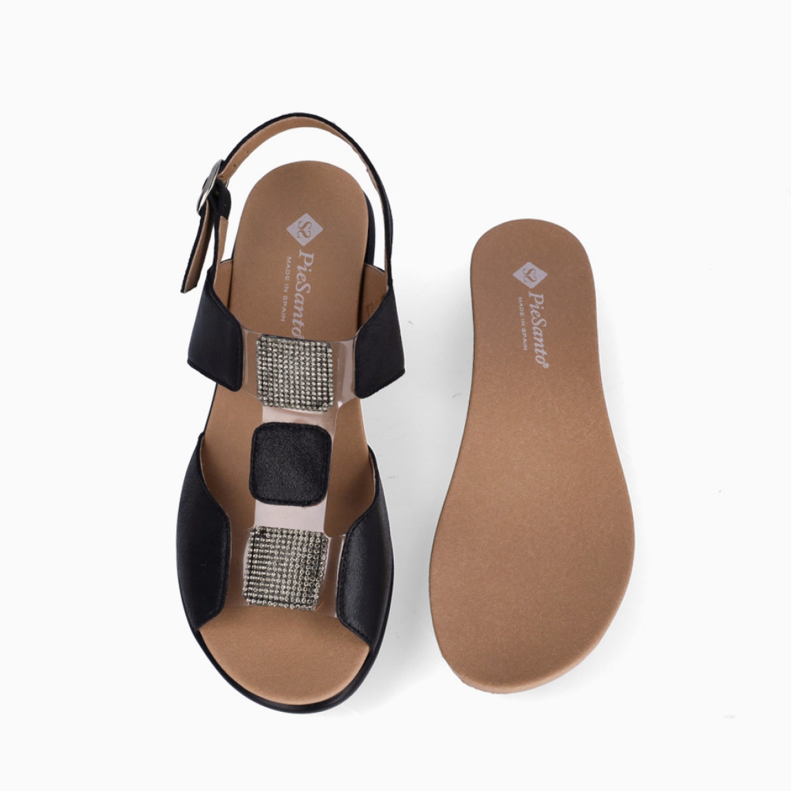 Sandalias de la marca PieSanto, modelo NIKITA. Exterior de las sandalias en piel color negro con detalle de brillantes en la pala. Interior de las sandalias en piel color marrón. Cierre de las sandalias PieSanto con hebilla en el tobillo y cuña de 6cm de altura. Estas sandalias PieSanto NIKITA son un complemento ligero y perfecto para esta temporada. No te puede faltar en el armario.