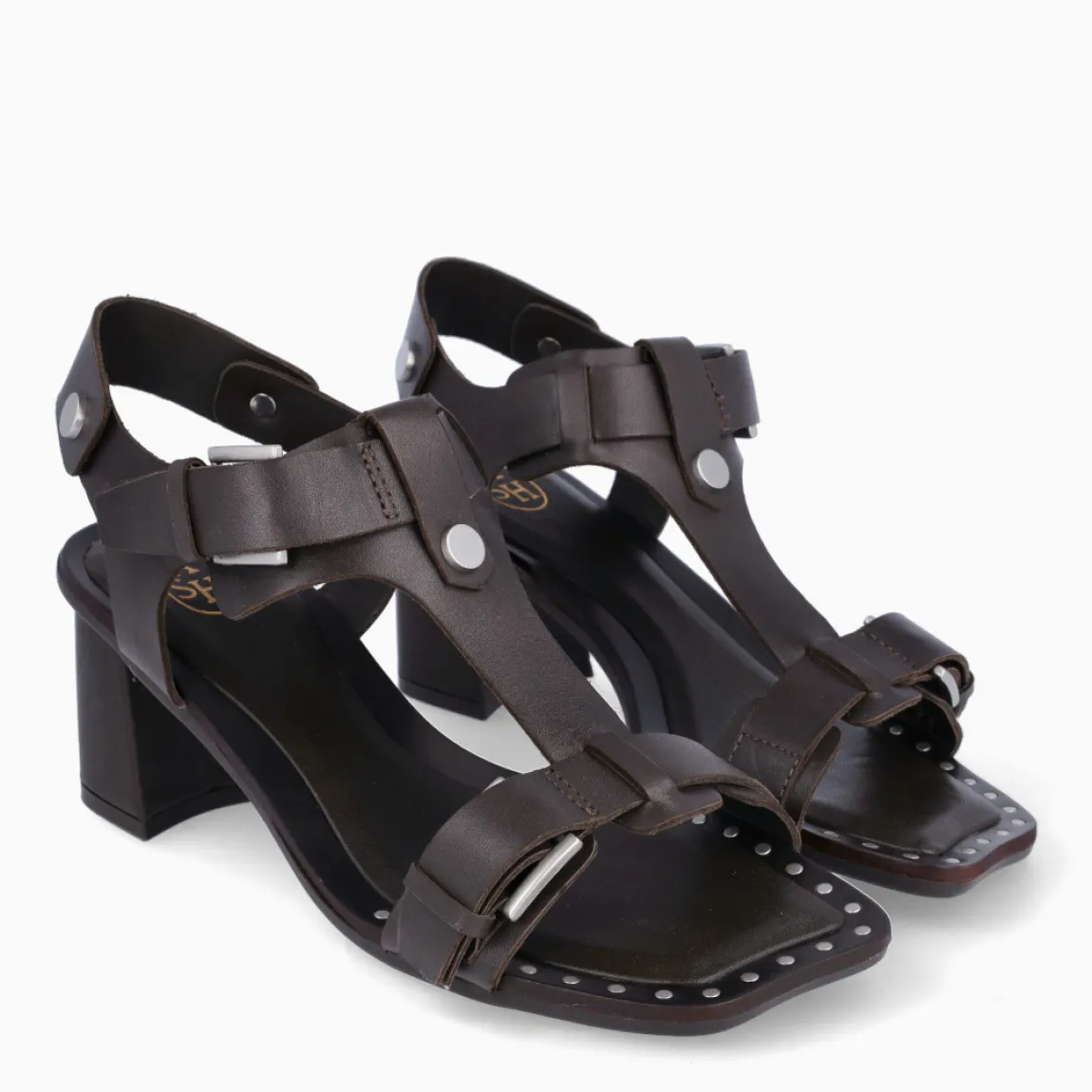 Sandalias de la marca ASH, modelo CRISS. Elaboradas en piel de color marrón con tiras en pala y detalle de botones, además de tachuelas en punta cuadrada. Interior en piel color marrón. Cierre de sandalias ASH con hebilla en tobillo. Suela con tacón de 6cm de altura. Estas sandalias ASH CRISS son ideales para llevar tus looks de temporada con estilo y comodidad!