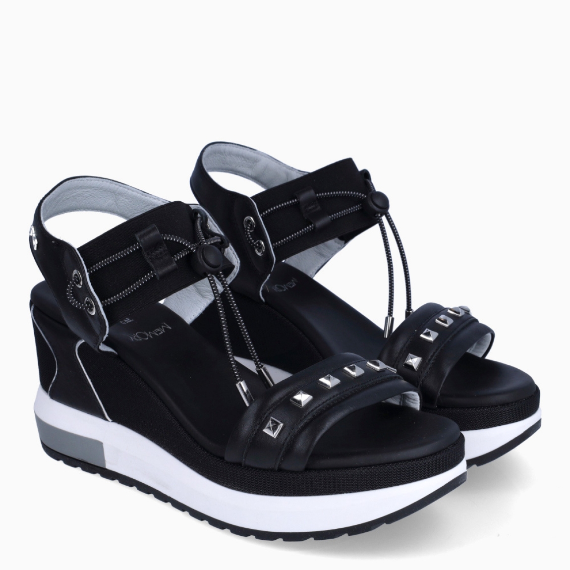 Sandalias de la marca Nerogiardini, modelo DANIE. Exterior de las sandalias en piel color negro con detalle de rejilla en la pala. Interior de las sandalias en piel color negro. Cierre de las sandalias Nerogiardini con gomas elásticas color negro. Sandalias con cuña de 8cm de altura. Estas sandalias Nerogiardini DANIE es un complemento clásico, inspirado en la comodidad, ligereza que necesitas en tu día a día.
