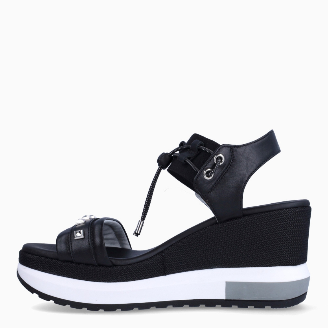 Sandalias de la marca Nerogiardini, modelo DANIE. Exterior de las sandalias en piel color negro con detalle de rejilla en la pala. Interior de las sandalias en piel color negro. Cierre de las sandalias Nerogiardini con gomas elásticas color negro. Sandalias con cuña de 8cm de altura. Estas sandalias Nerogiardini DANIE es un complemento clásico, inspirado en la comodidad, ligereza que necesitas en tu día a día.