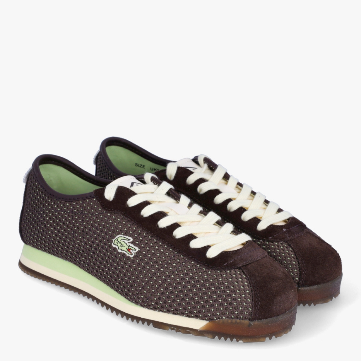Deportivas transpirables de la marca Lacoste, modelo CLUB-LOW. Deportivas elaboradas en textil efecto rejilla color marrón oscuro. Deportivas ligeras con efecto plegable, detalles de la marca serigafiados en exterior. Detalles de marca de cocodrilo en el lateral. Interior en piel. Cierre de deportivas Lacoste con cordones beig. Suela de cacuho con detalle en verde y efecto dentado. Estas deportivas CLUB-LOW Lacoste son unas clásicas, ideales para tu día a día!