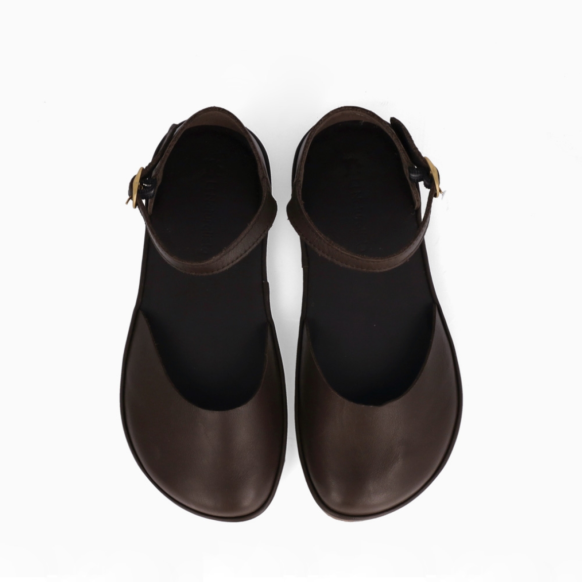 Merceditas de la marca El Naturalista, modelo MALÚ. Elaboradas en piel color marrón con punat redonda. Merceditas frailera con cierre de hebilla en tobillo. Merceditas El Naturalista MALÚ brina una experiencia barefoot con un diseño básico y duradero. No te puede faltar en el armario esta temporada!