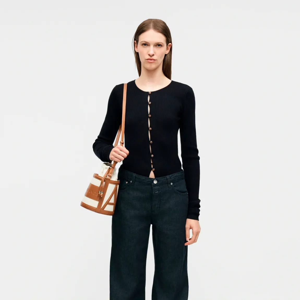 Bolso tipo cubo de la marca Armani Exchange, modelo RACHEL. Bolso elaborado en polipiel color cuero. Tiene una silueta depurada, definida por líneas suaves y una paleta de colores neutros, se presta a innumerables combinaciones de estilo, con logo en todo el bolso. Con asas extraíbles de hombro. Bolso Armani Exchange RACHEL, un accesorio imprescindible para la mujer moderna que busca un toque de lujo discreto, perfecto para guardar sus secretos cotidianos con elegancia y sofisticación.