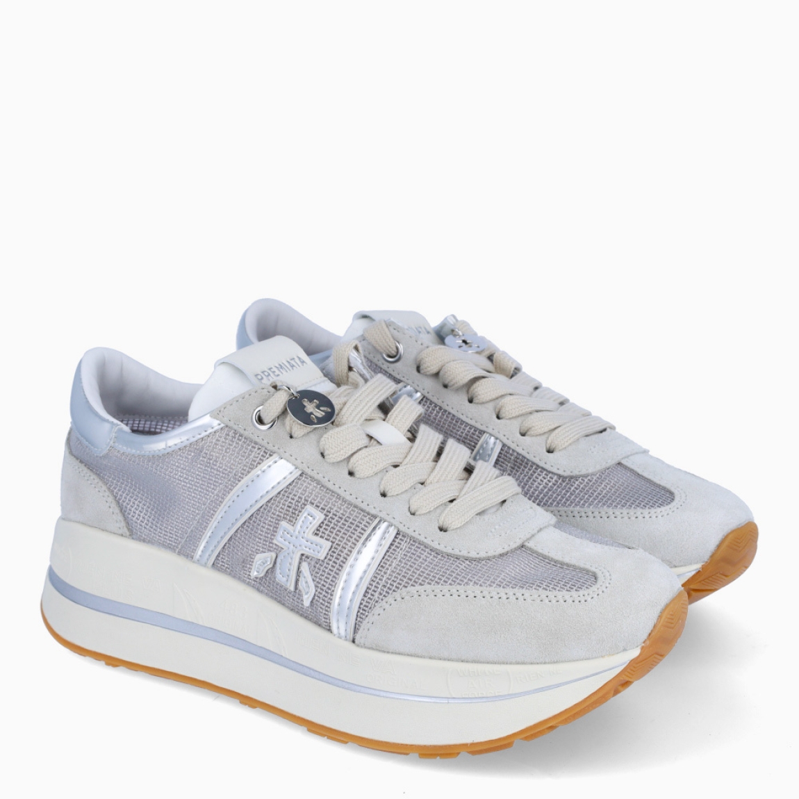 Deportiva de la marca Premiata, modelo Bethcoin. Exterior de la deportiva en rejilla color plata con detalles en ante. Interior de la deportiva de piel de color blanco. Cierre de la deportiva con cordones. Suela de la deportiva de goma con 3cm de plataforma. Deportiva con plantilla extraíble acolchada para garantizar la máxima comodidad a cada paso. La deportiva Bethcoin de Premiata es la evolución de los modelos Conny y Beth, fusionados en una nueva versión ideal para marcar estilo.