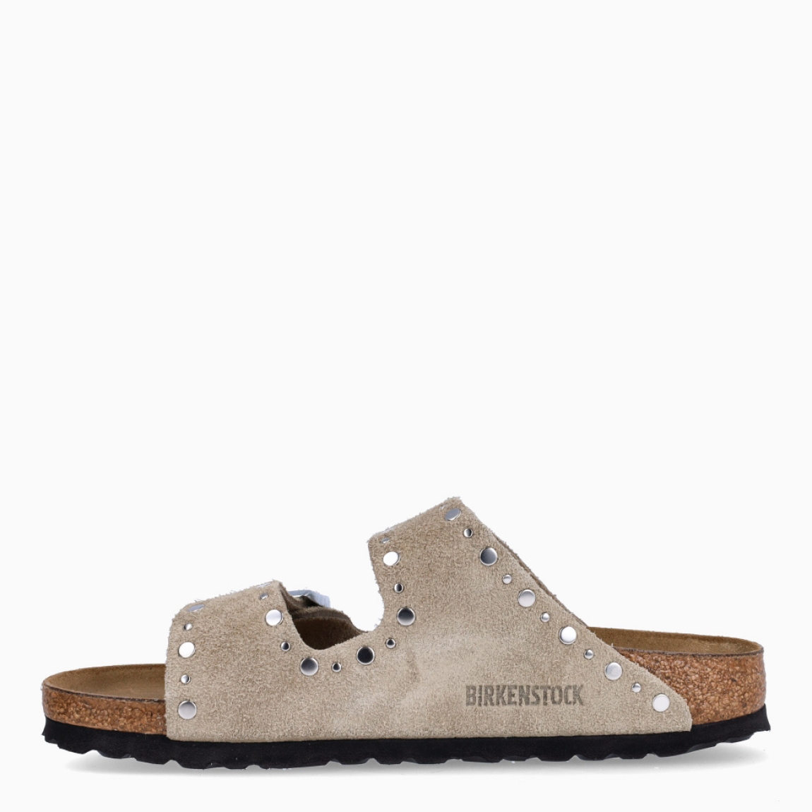 Sandalias de la marca Birkenstock, modelo ARIZONA RIVET. Sandalias elaboradas en ante de color taupe con detalle de tachuelas y con una base de corcho y látex de forma anatómica. Cierre de las sandalias con doble hebilla de espiga de metal con ajuste individual. Estas sandalias Birkenstock ARIZONA RIVET es un complemento clásico para tus looks de temporada, con un diseño sencillo atemporal y una ligereza que te dará la comodidad que necesitas en tu día a día.