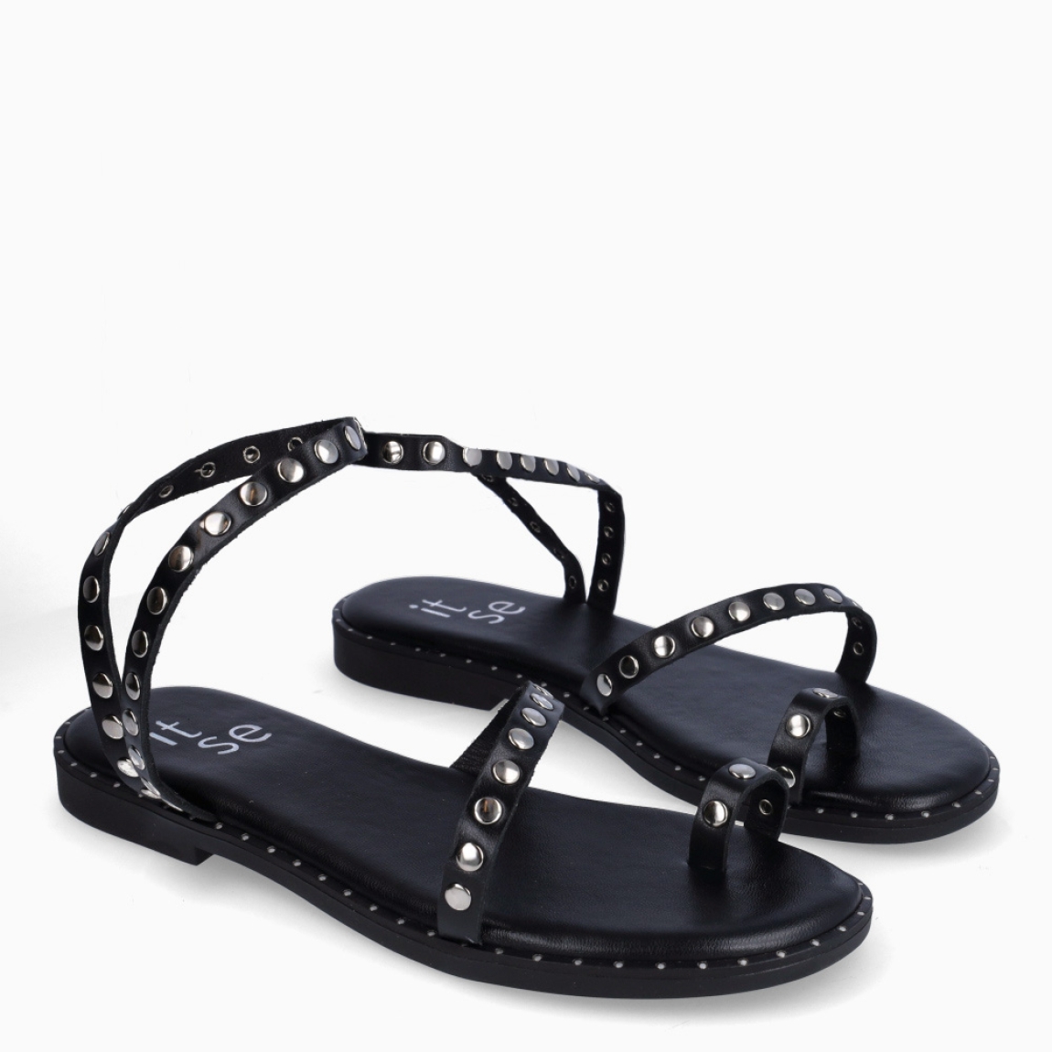 Esclavas de la marca Itse, modelo SELENA. Elaboradas en piel color negro con tachuelas y anillo al dedo. Interior en piel color negro. Suela plana de goma. Estas esclavas Itse SELENA son un complemento ideal para esta temporada!