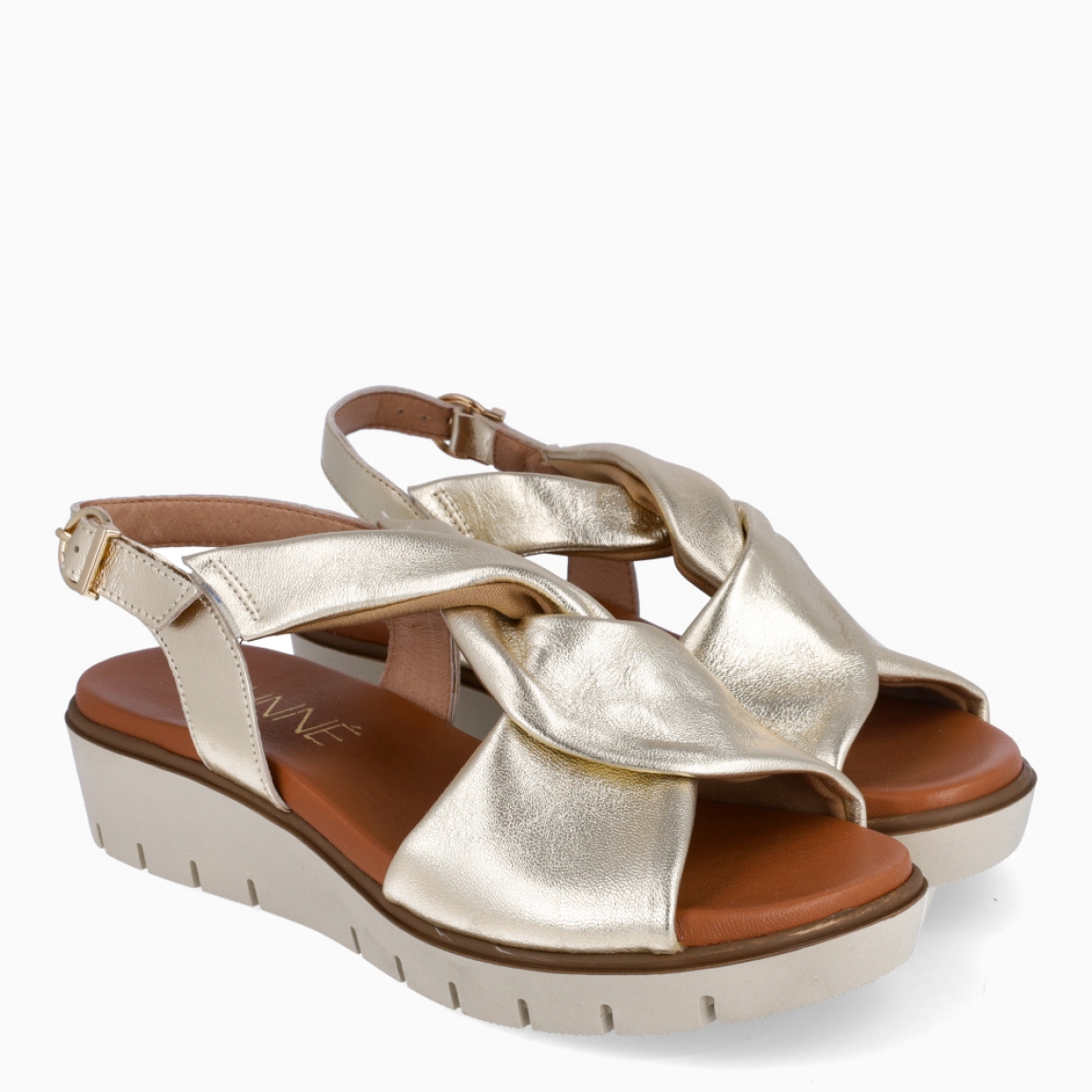 Sandalias de la marca Munné, modelo JAZMIN. Exterior en piel color platino con tiras cruzadas en pala. Interior en piel color camel. Cierre de sandalias Munné con hebilla en tobillo,y suela dentada con cuña de 3cm de altura. Estas sandalias Munné JAZMIN son ideales en comodidad y ligereza, perfectas para llevarlas a todos lados esta temporada!