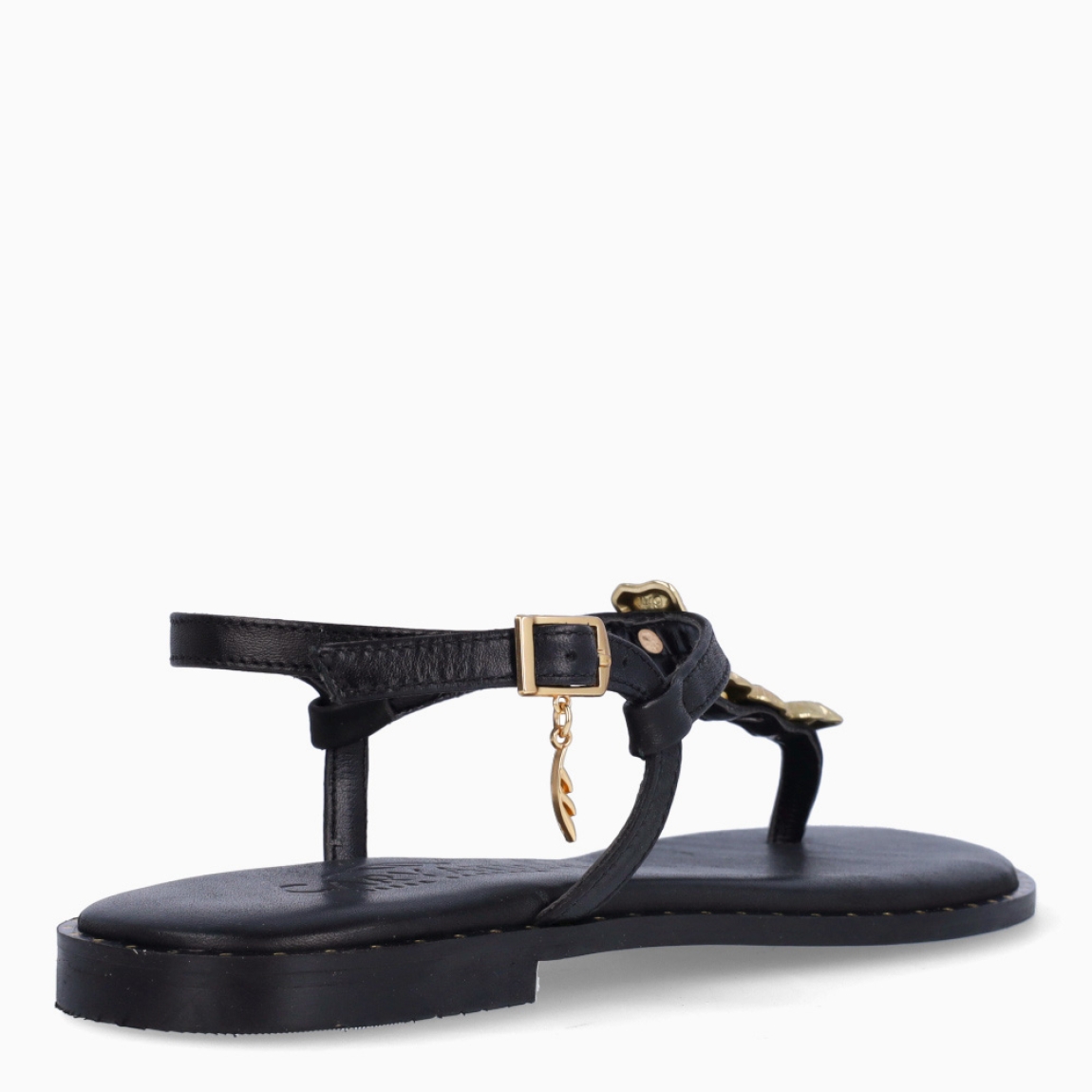 Esclavas de la marca Caryatis, modelo TILA. Exterior de las esclavas en piel color negro con adornos brillantes color oro. Cierre de las esclavas con hebilla y suela plana. Estas esclavas Caryatis TILA es un producto de alta calidad, pensado en la comodidad y elegancia. No puede faltar en tu armario de temporada.