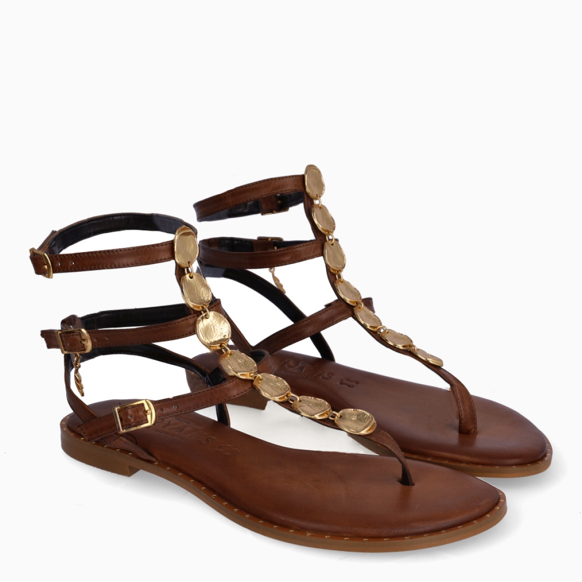 Esclavas de la marca Caryatis, modelo BEATRIZ. Exterior de las sandalias en piel color marrón con detalles en metal dorado en la pala. Cierre de las sandalias con triple hebilla. Estas sandalias Caryatis BEATRIZ, tiene un estilo elegante e innovador, que te hará crear diferentes looks elegantes.