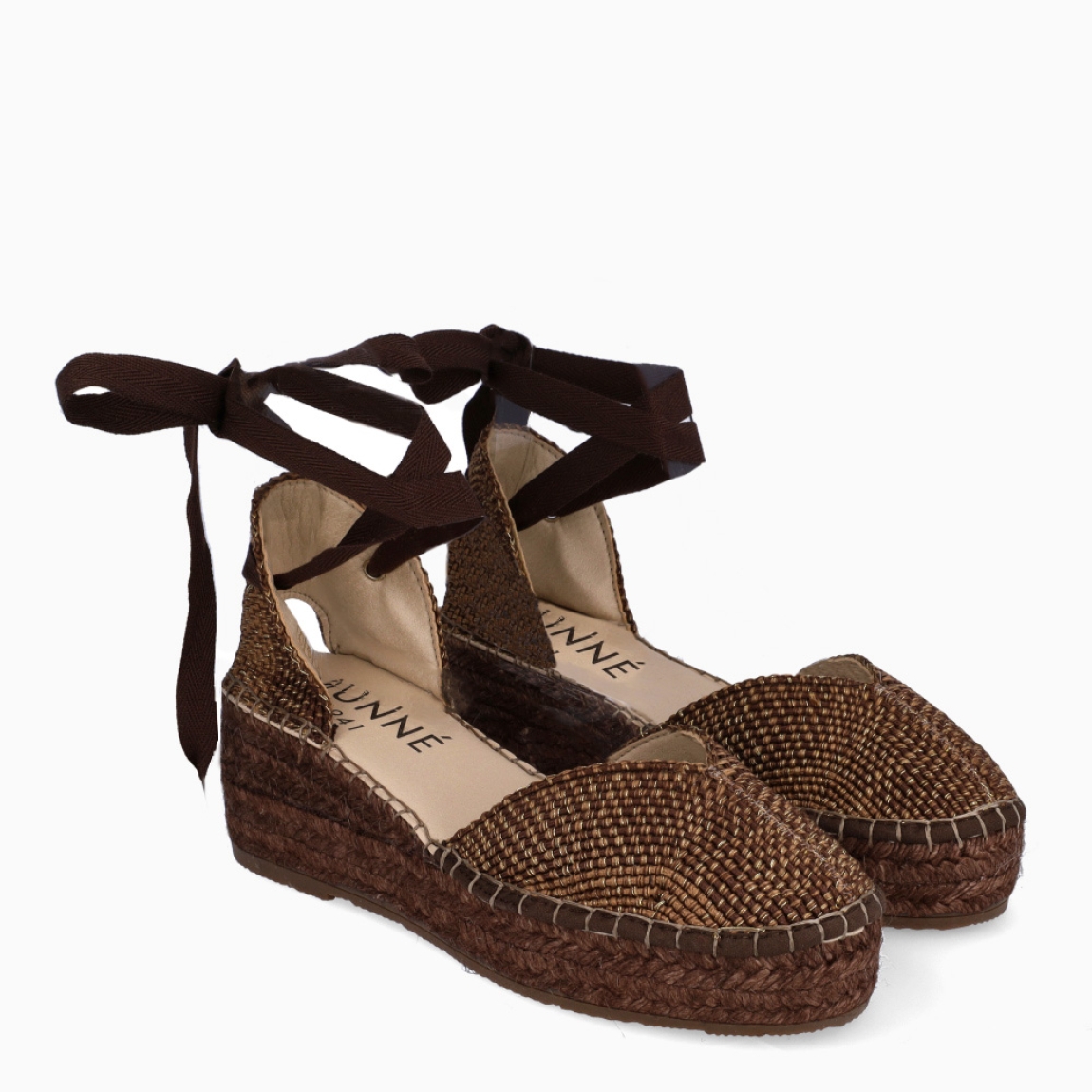 Alpargatas destalonadas de la marca Munné, modelo OLENKA. Exterior en textil color marrón con punta redonda. Interior en piel color nude. Alpargata clásica con cierre de cordones para amarrar. Alpargata con cuña de piel trenzada de 6cm de altura. Estas alpargatas Munné OLENKA son ideales para esta temporada!