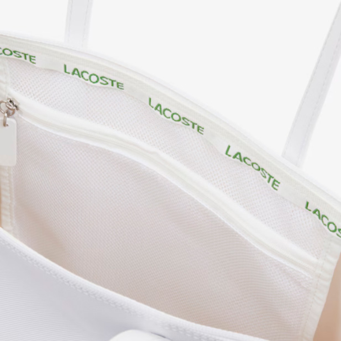 Bolso de la marca Lacoste, modelo L12. Elaborado en plástico rugoso color blanco. Este diseño de dimensiones generosas tiene espacio para todos tus objetos personales esenciales, incluido un portátil de 15